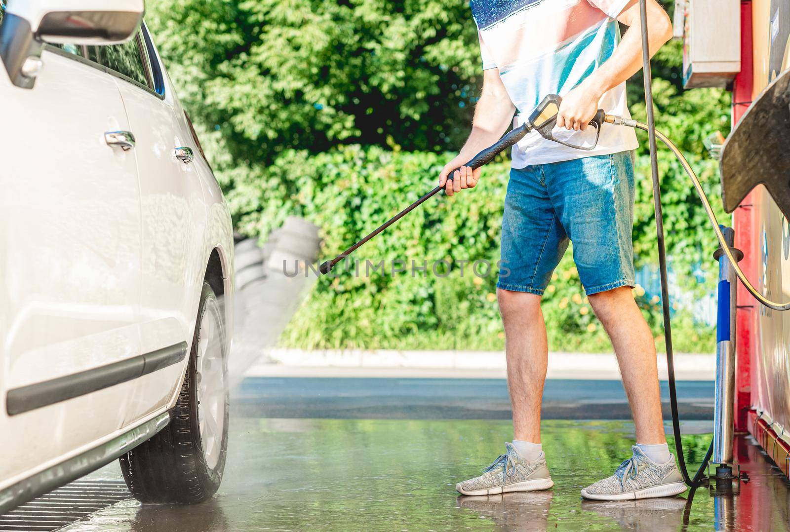 Man is washing car with high pressure water