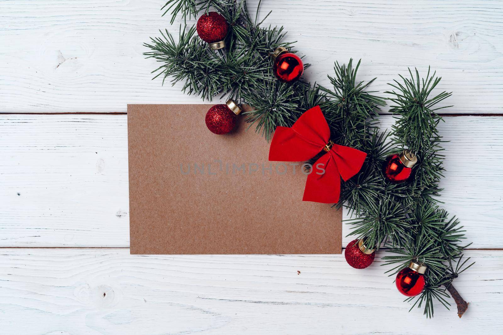 White wooden background with coniferous branches and Christmas decorations, top view