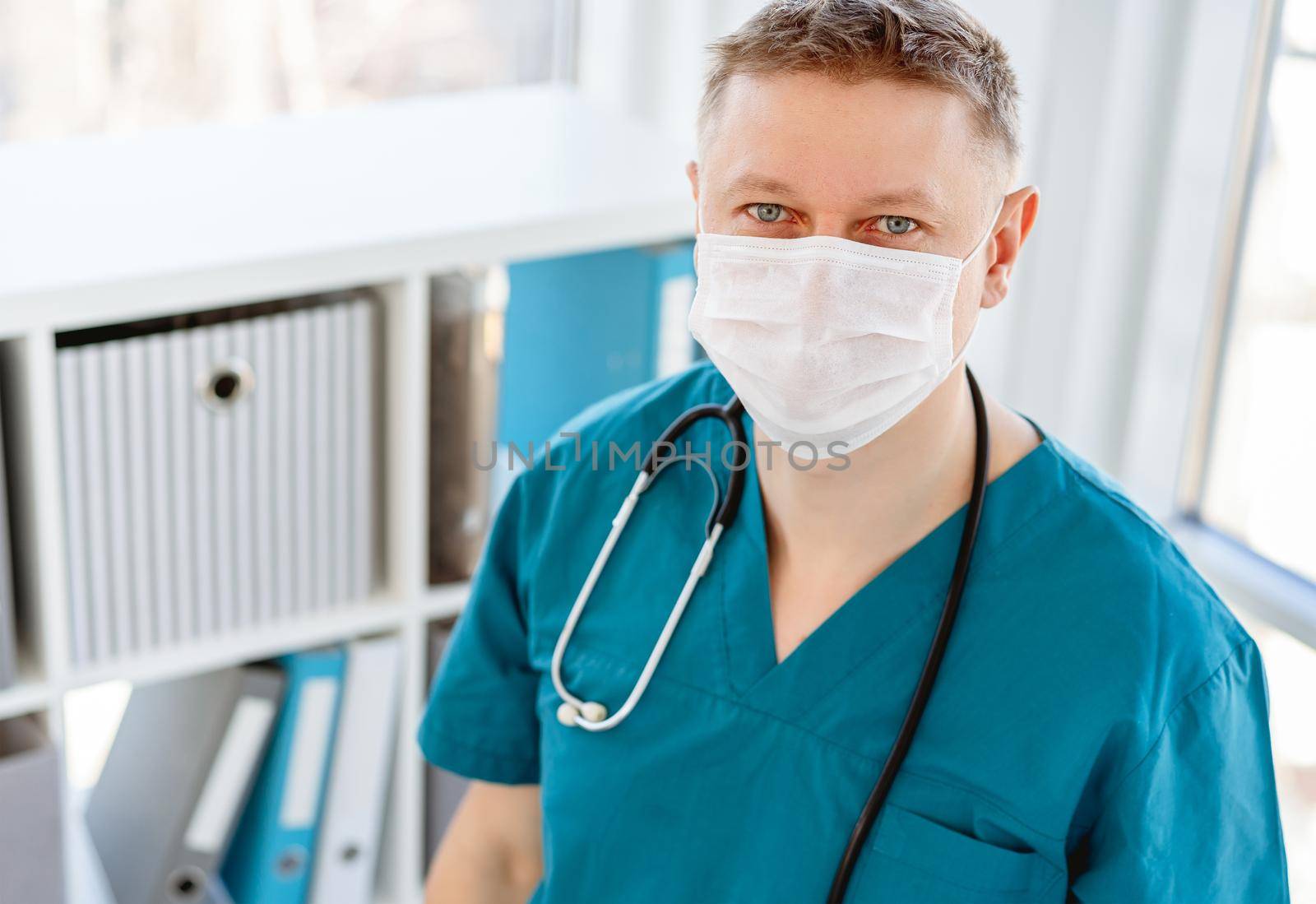 Doctor in protective mask at workplace