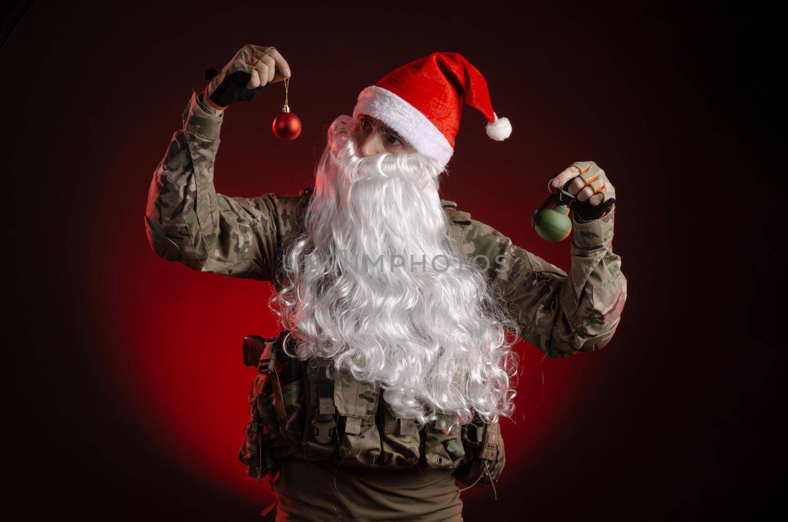 the man in a military uniform with a gun and a Santa Claus hat