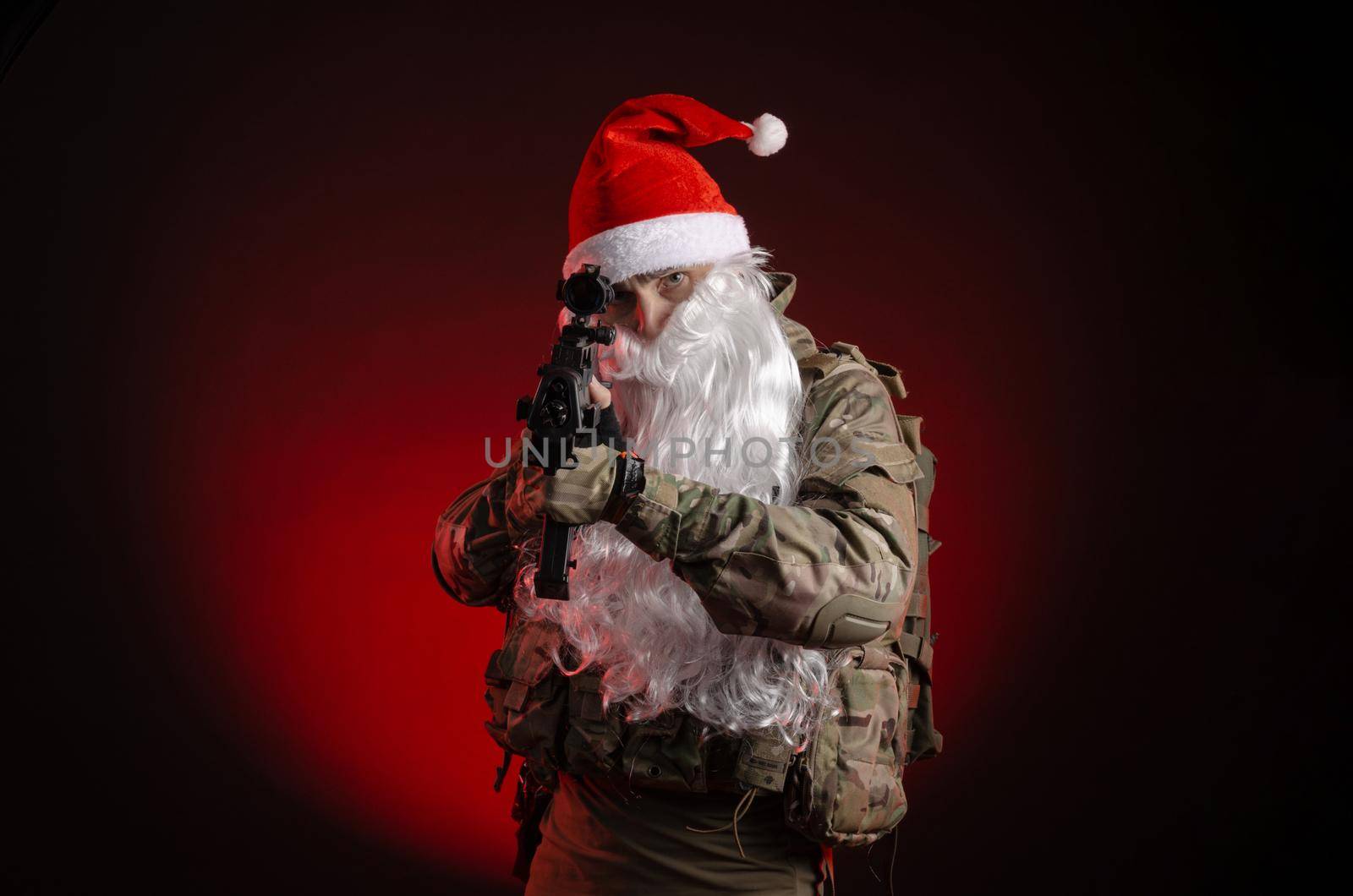 the man in a military uniform with a gun and a Santa Claus hat