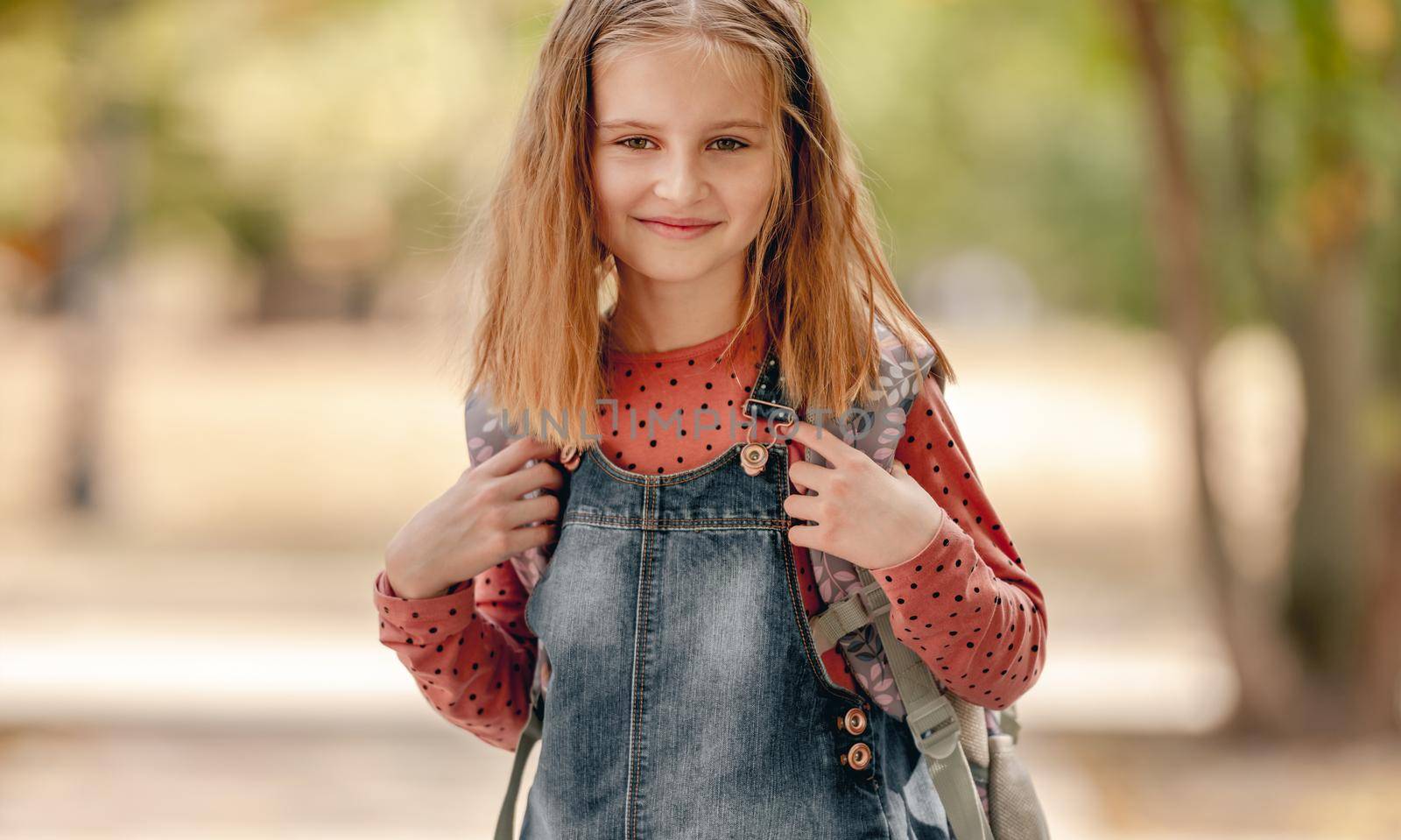 Preteen school girl with backpack closeup portrait outdoors. Pretty pupil female kid after education class in autumn park