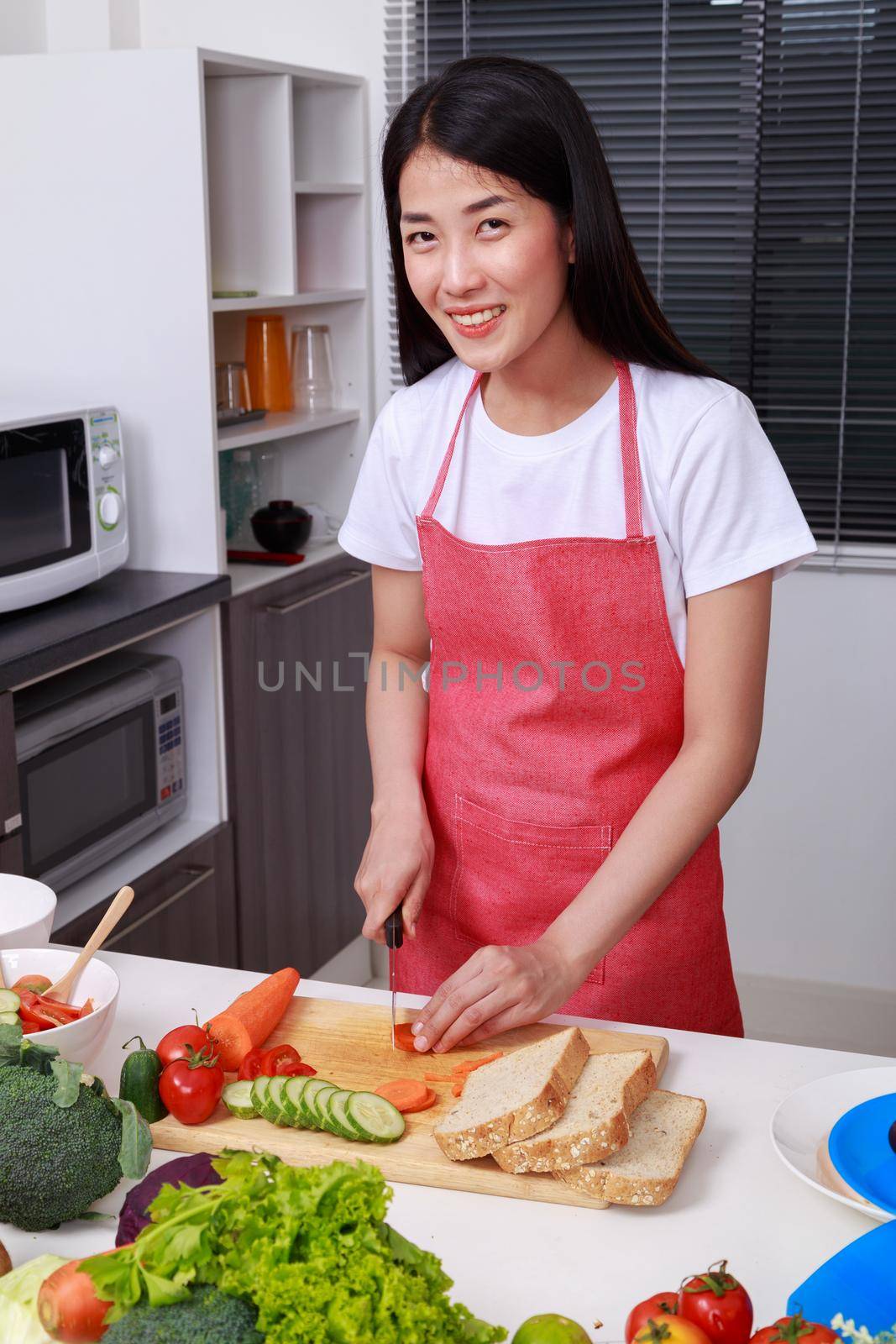 woman cutting carrot in kitchen room at home
