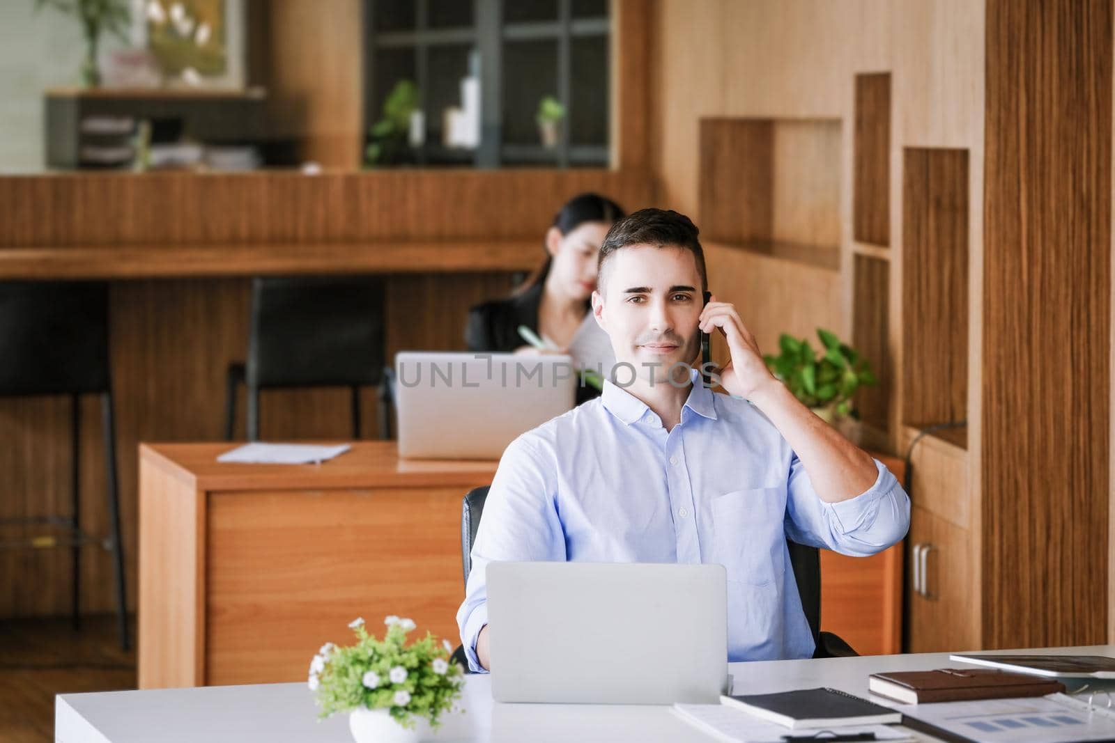 Male marketing manager using phone to talk to venture capital firm to increase profit potential