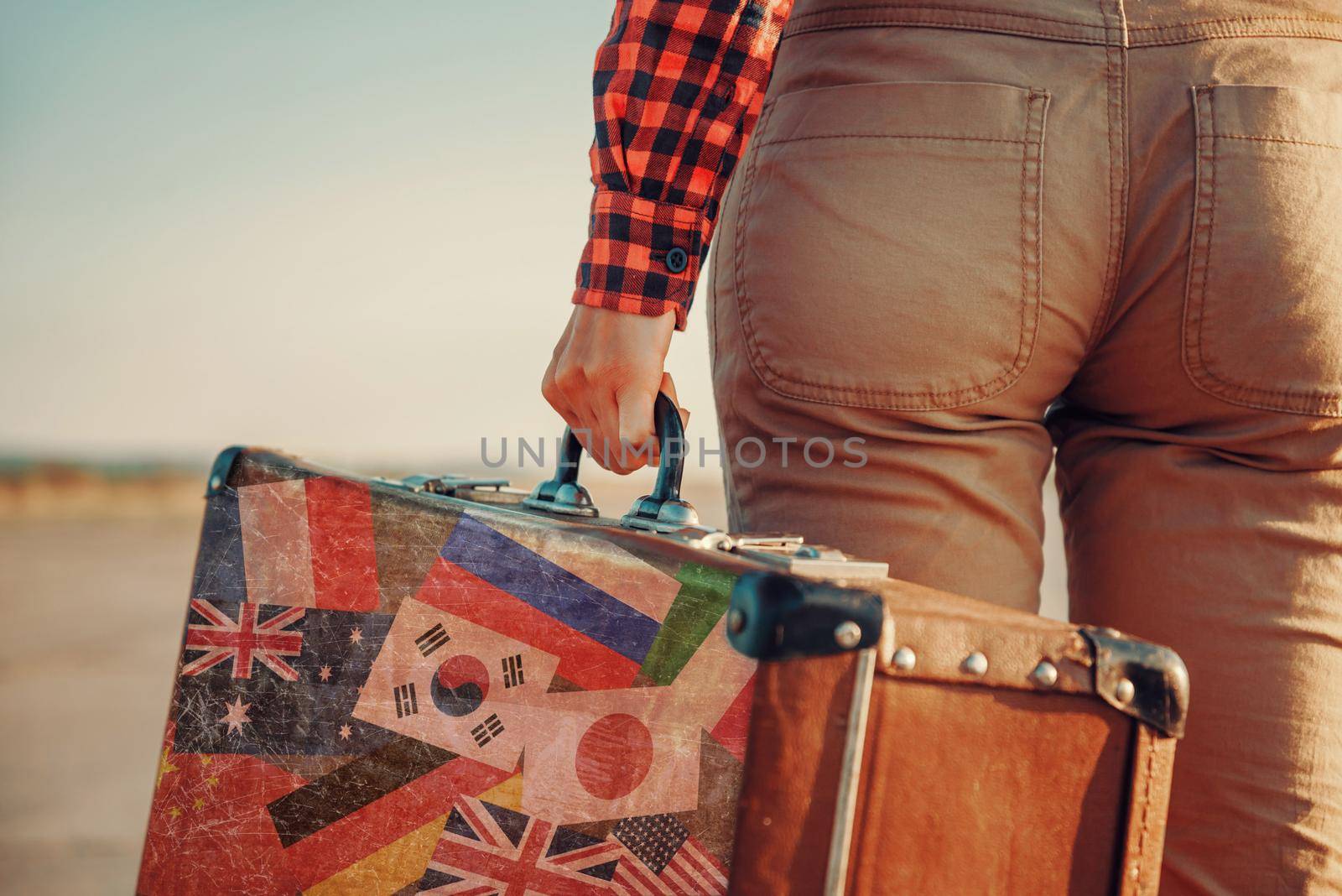 Traveler with a suitcase. Suitcase with stamps flags of different country