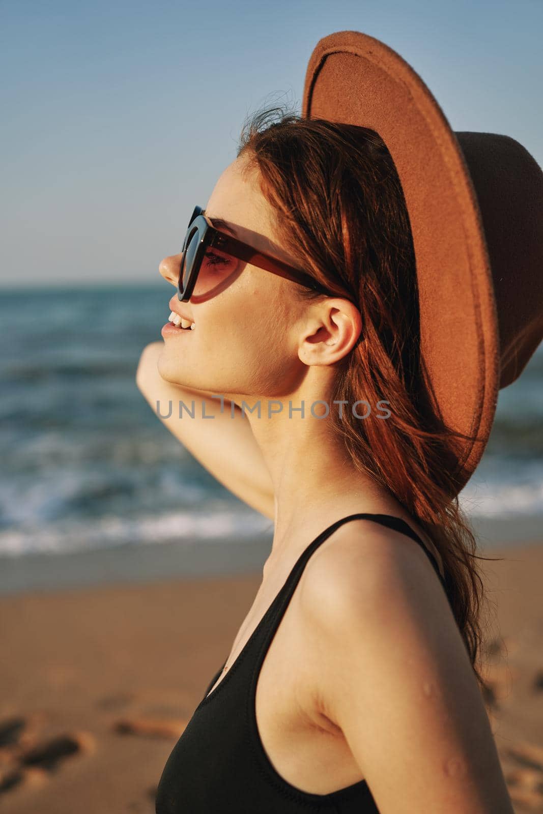 cheerful woman in sunglasses Sandy coast landscape sun. High quality photo