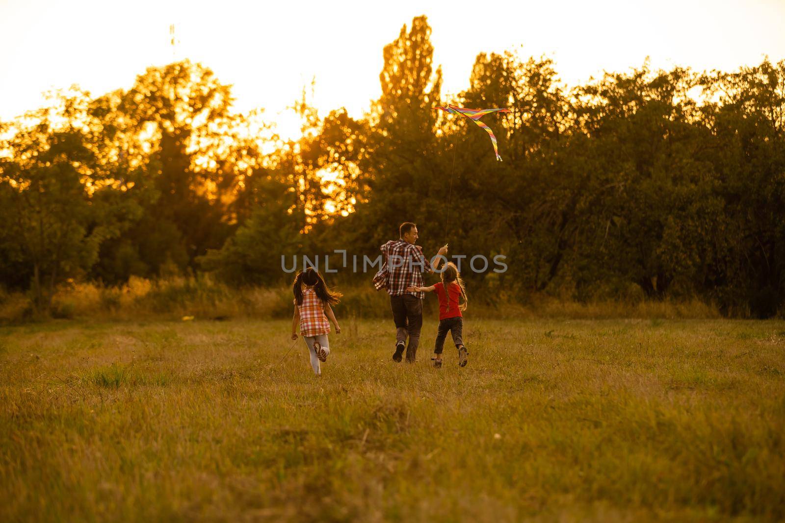 happy family father and child daughter run with a kite on meadow by Andelov13