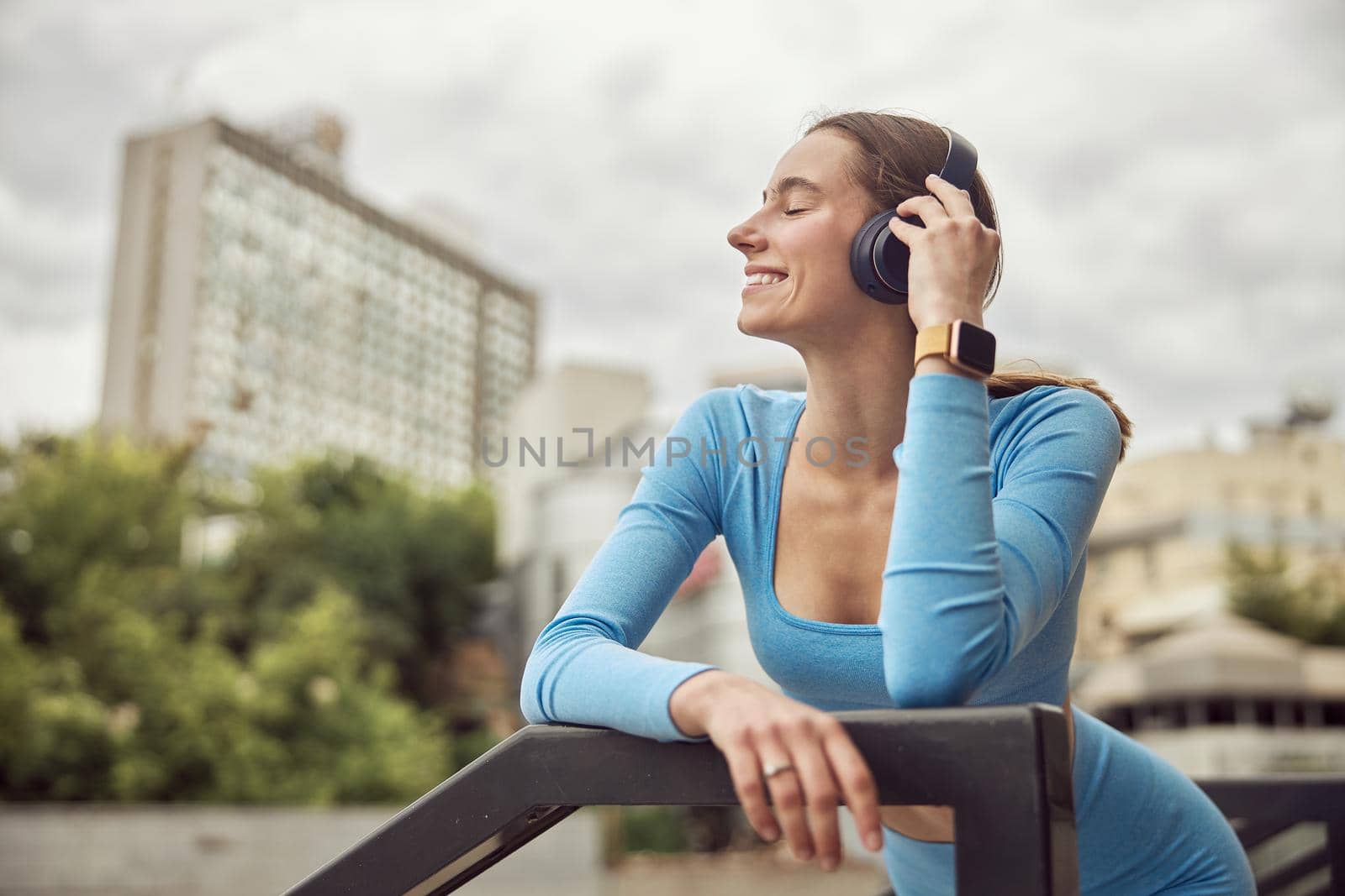 Beautiful fit caucasian woman is doing exercises outdoors at the city by Yaroslav_astakhov