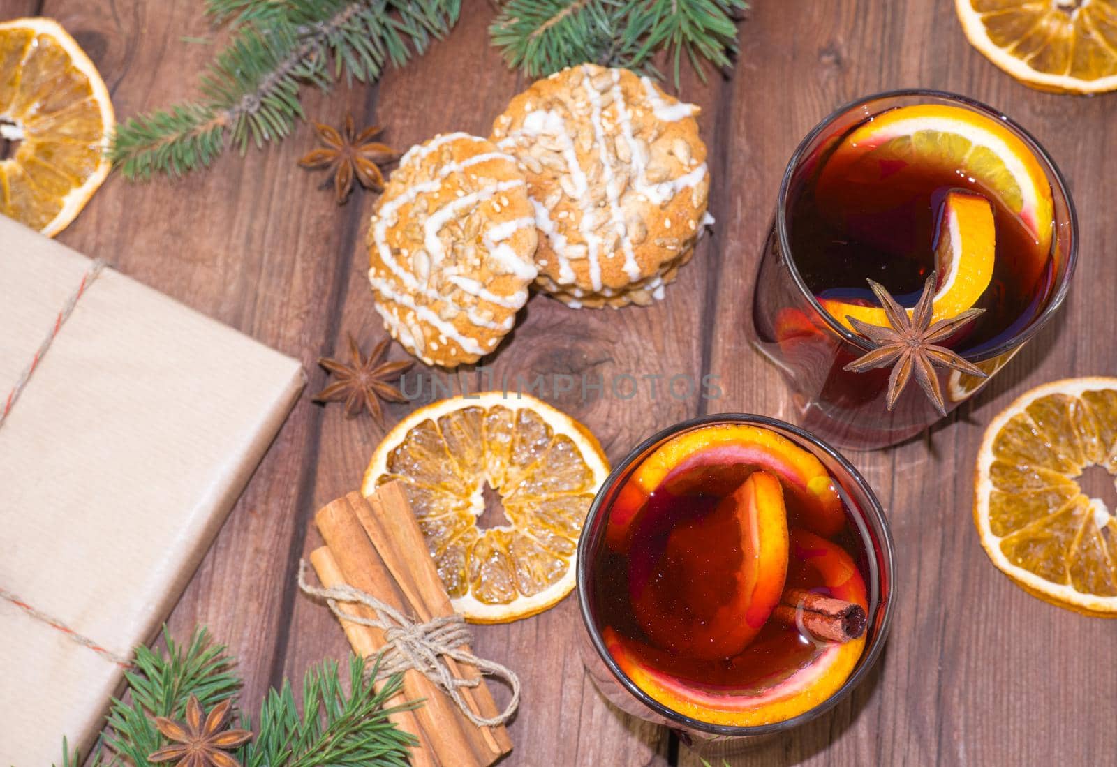 Mulled wine and spices on a wooden background with branches of a Christmas tree. Selective focus.