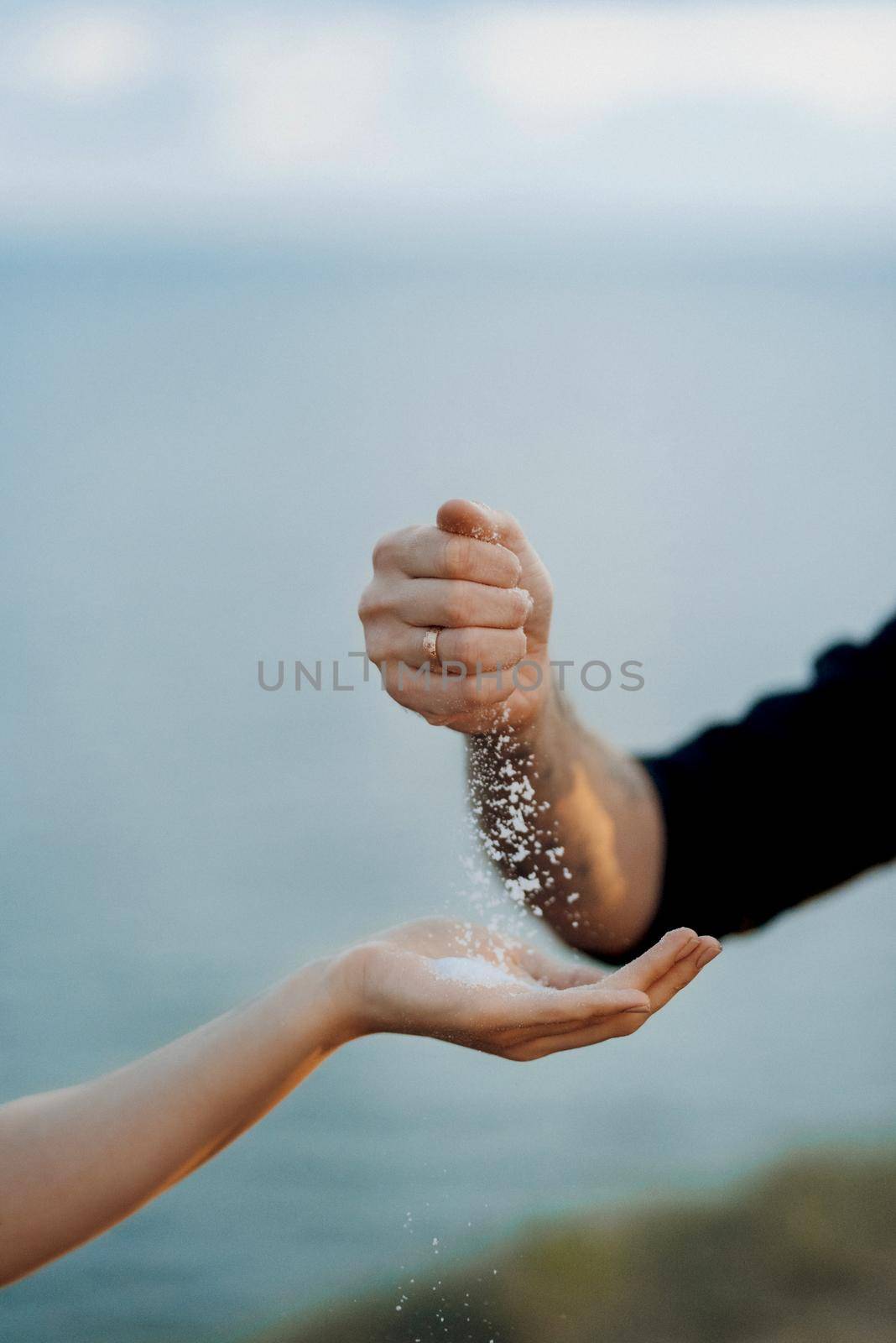 the groom sprinkles solv on the bride's hand according to tradition at the ceremony