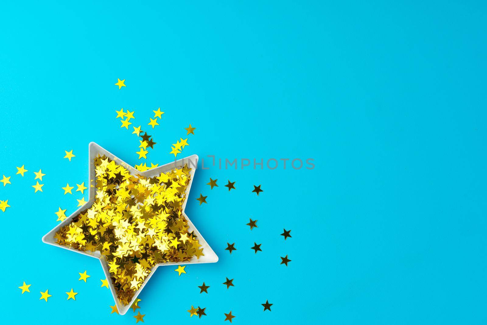 Star shaped plate with golden confetti top view copy space