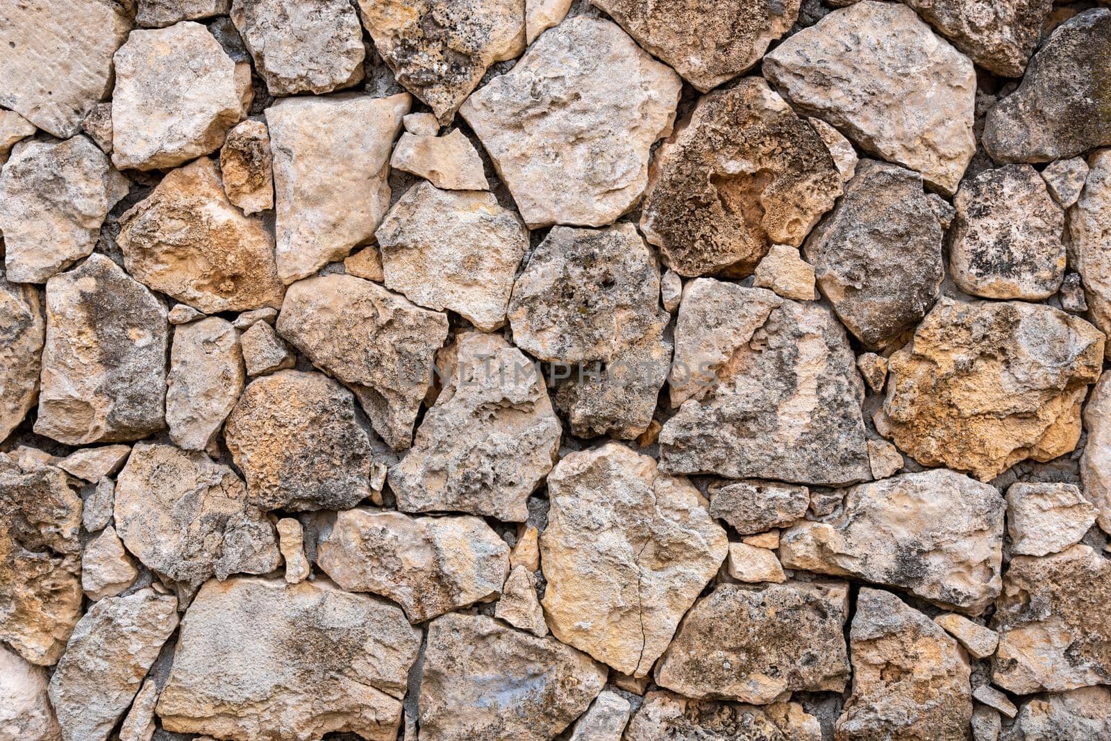 Background of limestone masonry. The surface is decorated with natural material. The wall is made of wild stone by panophotograph