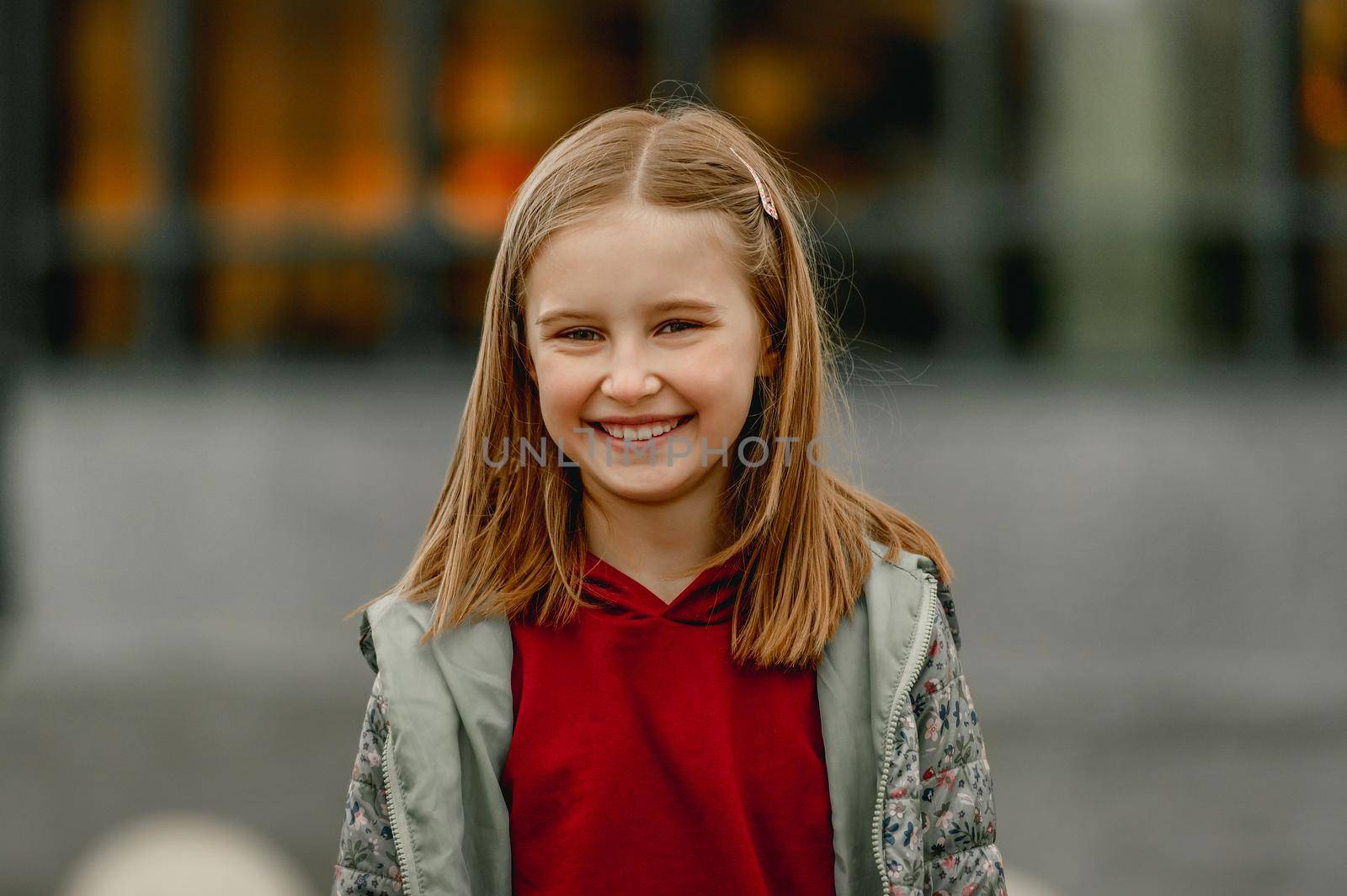 Pretty girl kid autumn portrait outdoors. Preteen female child looking at camera and smiling