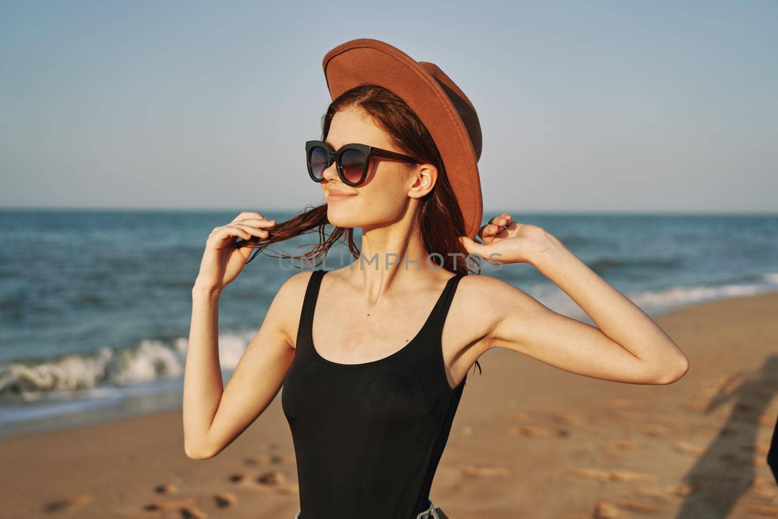 woman in a hat sunglasses by the ocean travel sun. High quality photo