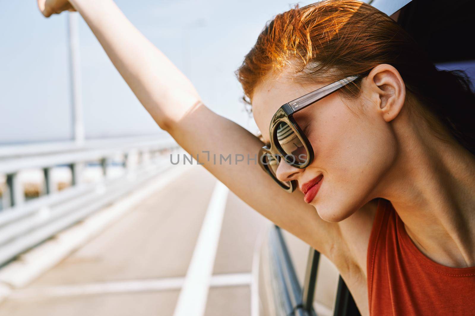 cheerful woman peeking out of the car window trip adventure lifestyle. High quality photo