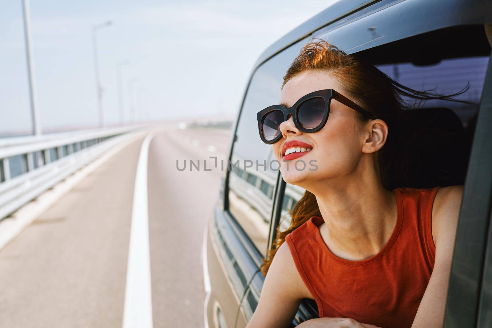 woman looking out of car window wearing sunglasses travel lifestyle. High quality photo