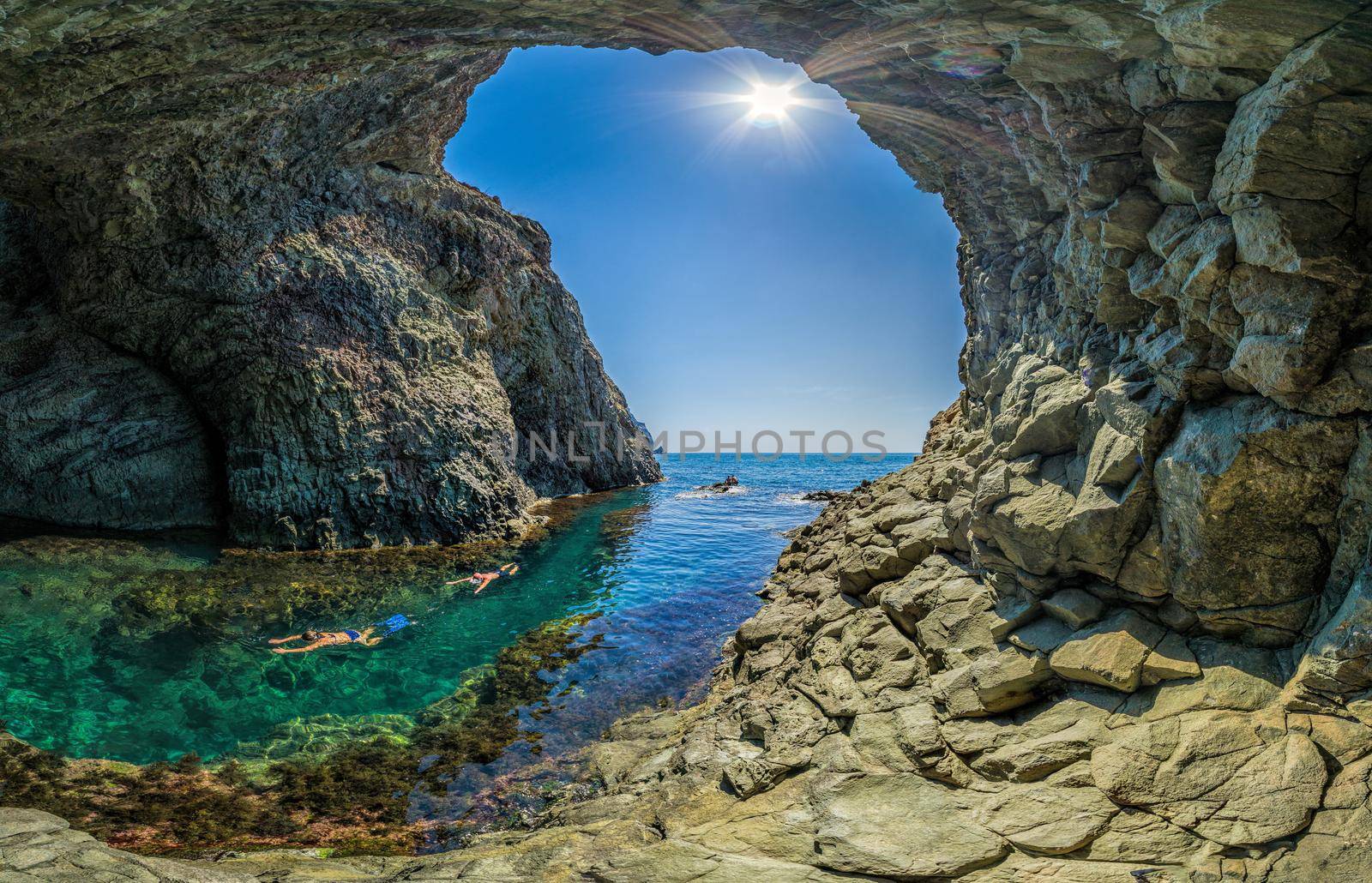girl dive in the Diana's grotto Sevastopol. Fiolent, Crimea on a background of rocky shores. The concept of an travel, relax, active and healthy life in harmony with nature