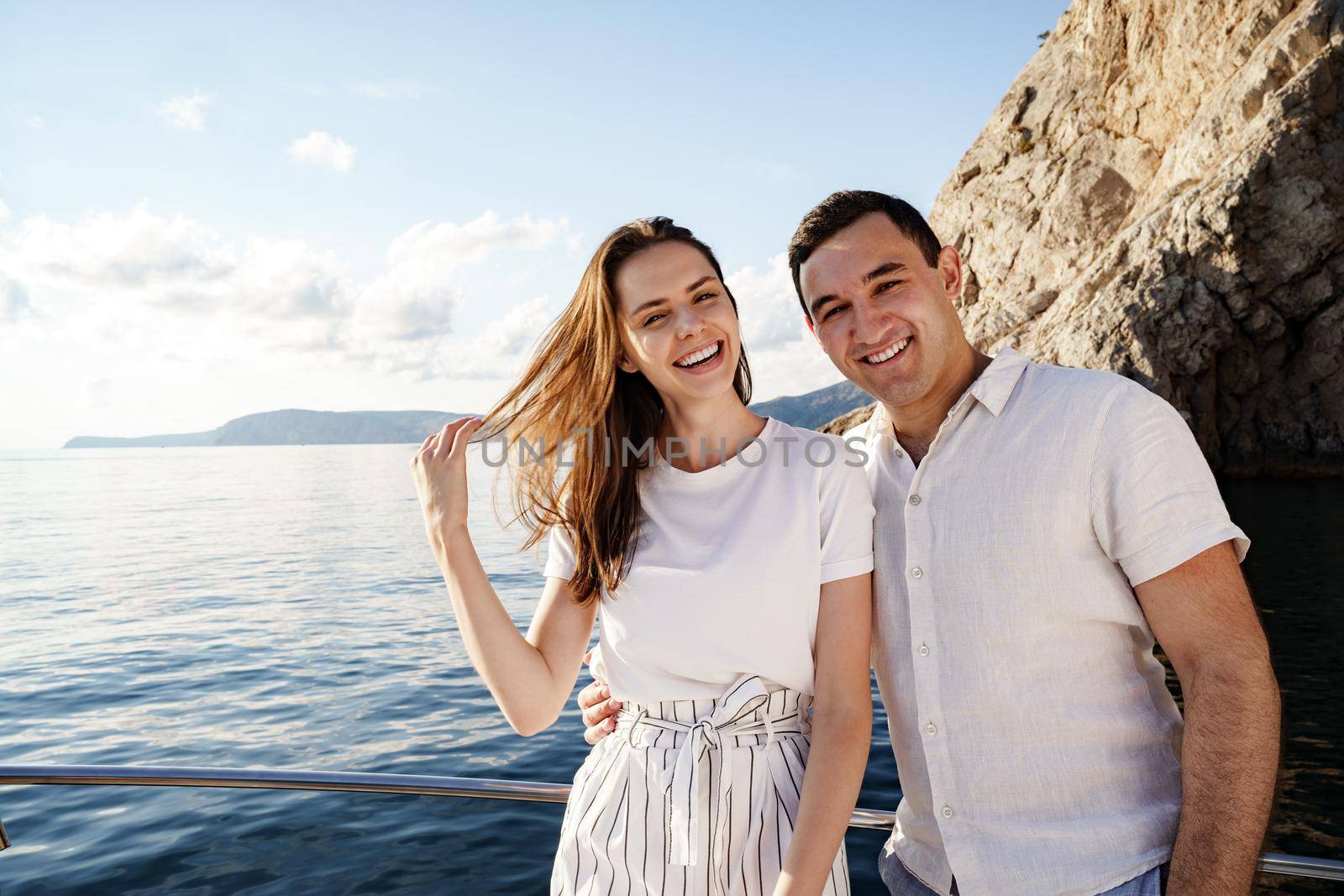 Happy couple in love on a yacht in summer on romantic vacation