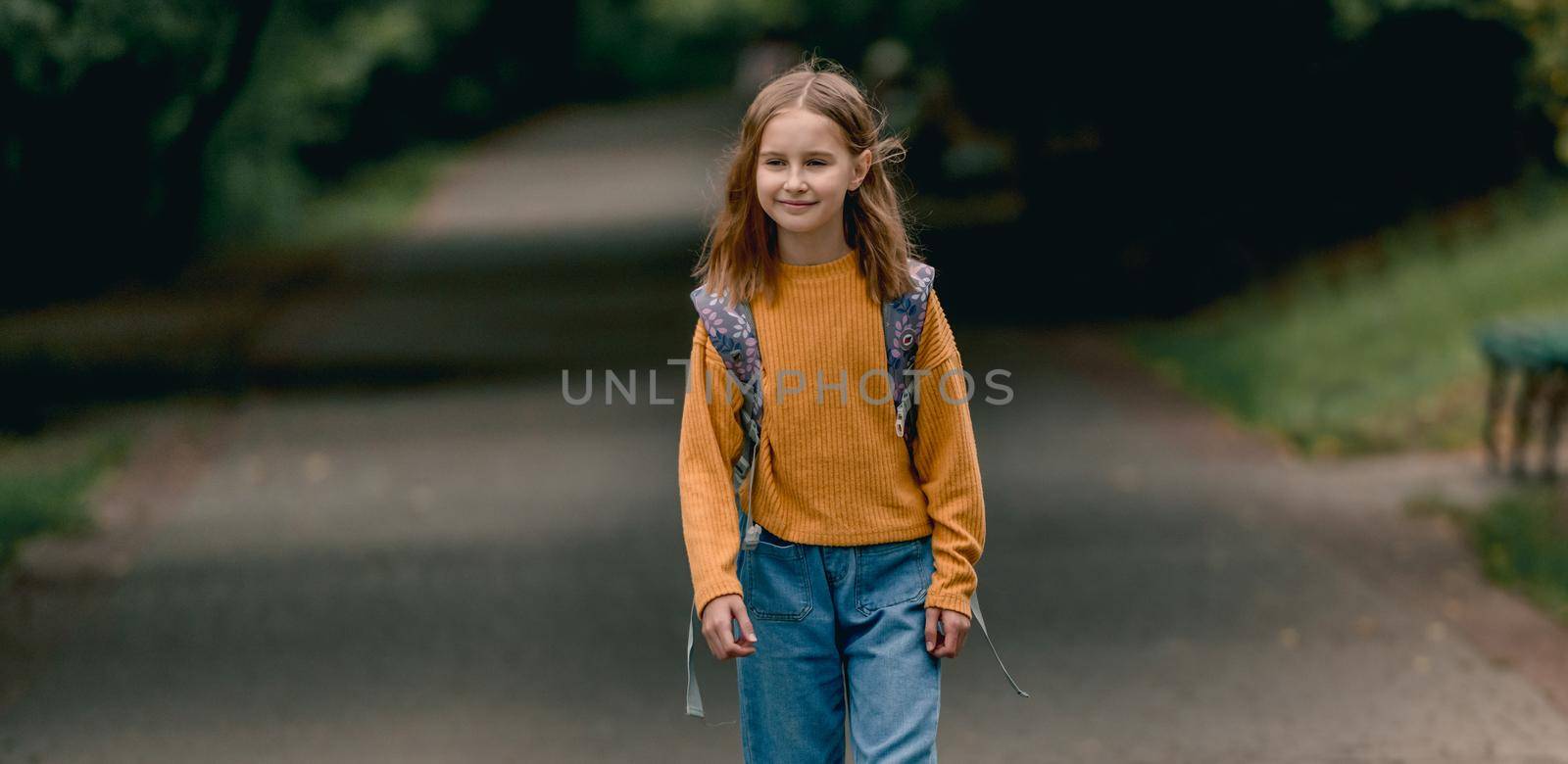 Happy school girl with backpack portrait outdoors. Portrait of schoolchild at autumn at the street