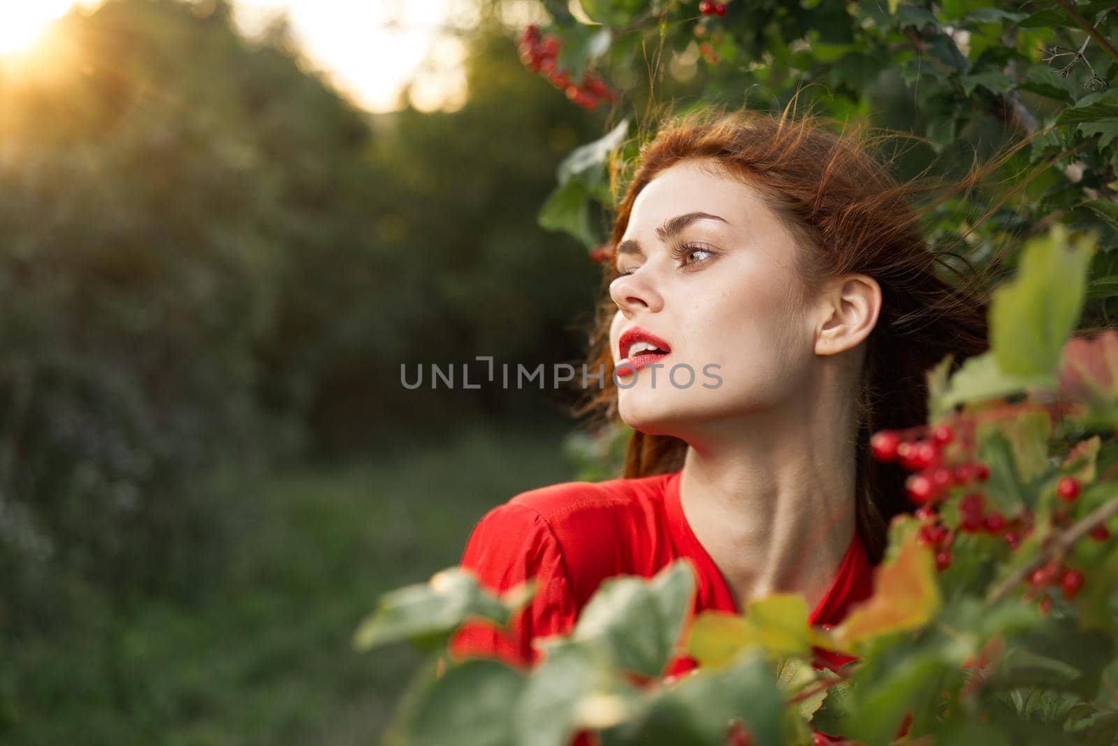 pretty woman in red shirt nature green leaves summer. High quality photo