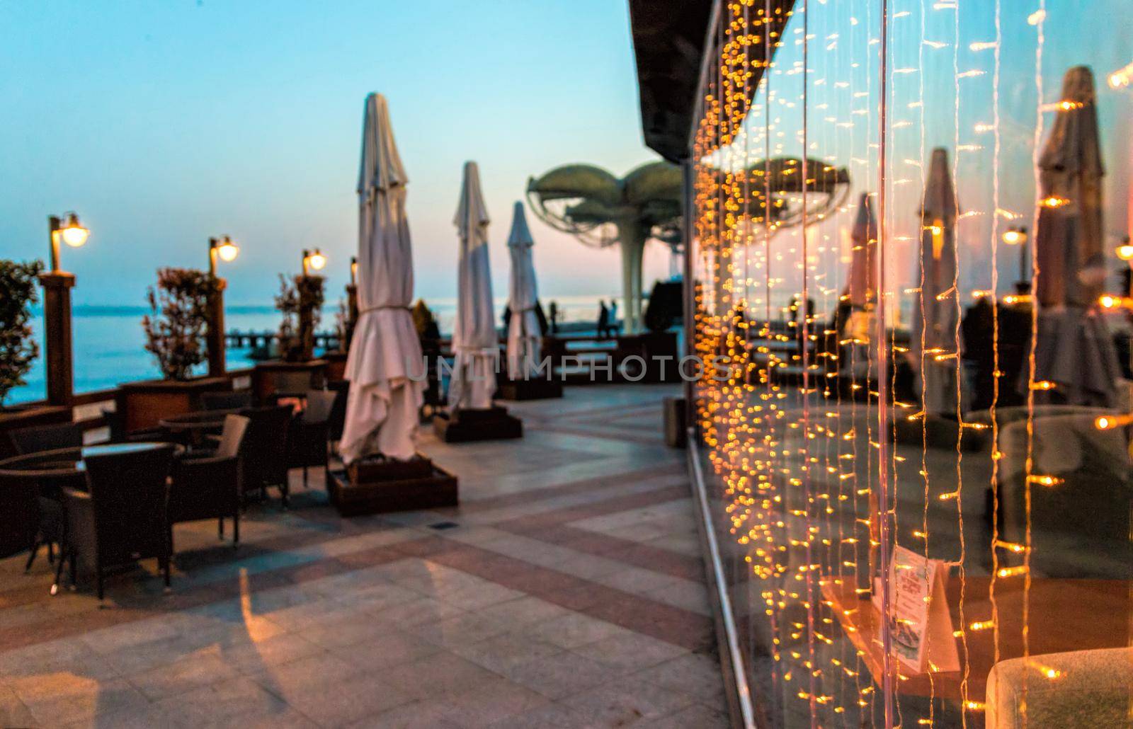 Soft focus. Restaurant terrace at sunset without people. Blinking blur background.