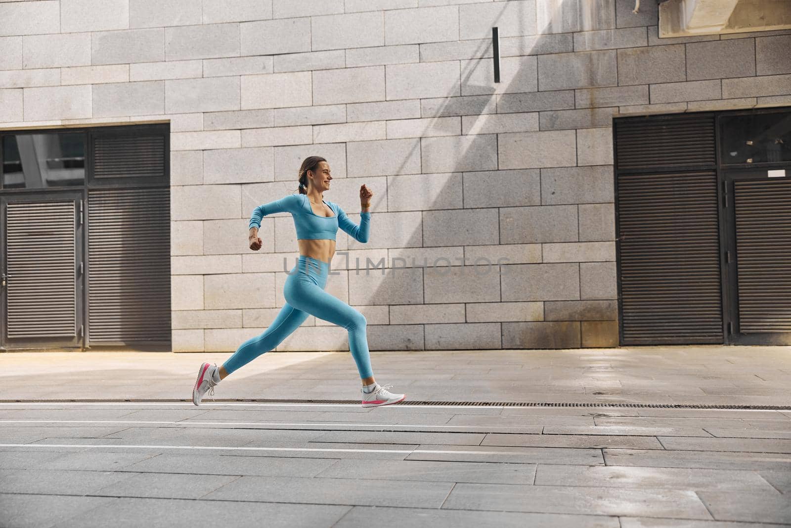 Beautiful fit young woman jogger is running outdoors by Yaroslav_astakhov