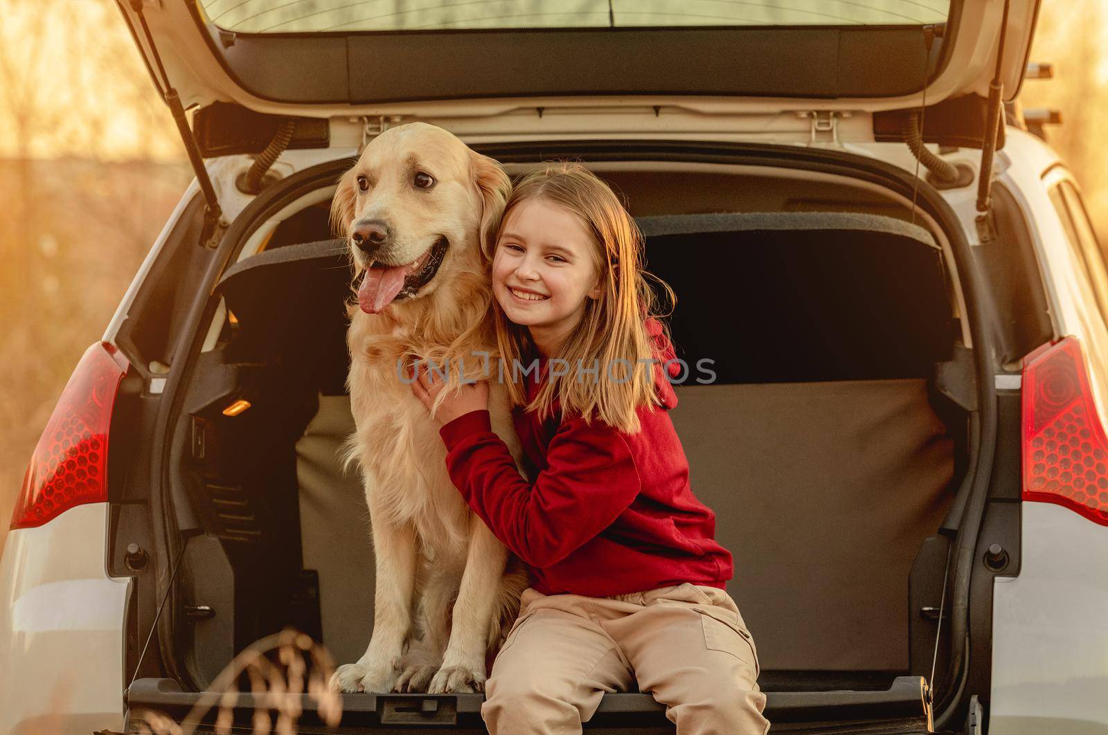 Girl with golden retriever dog in car by tan4ikk1