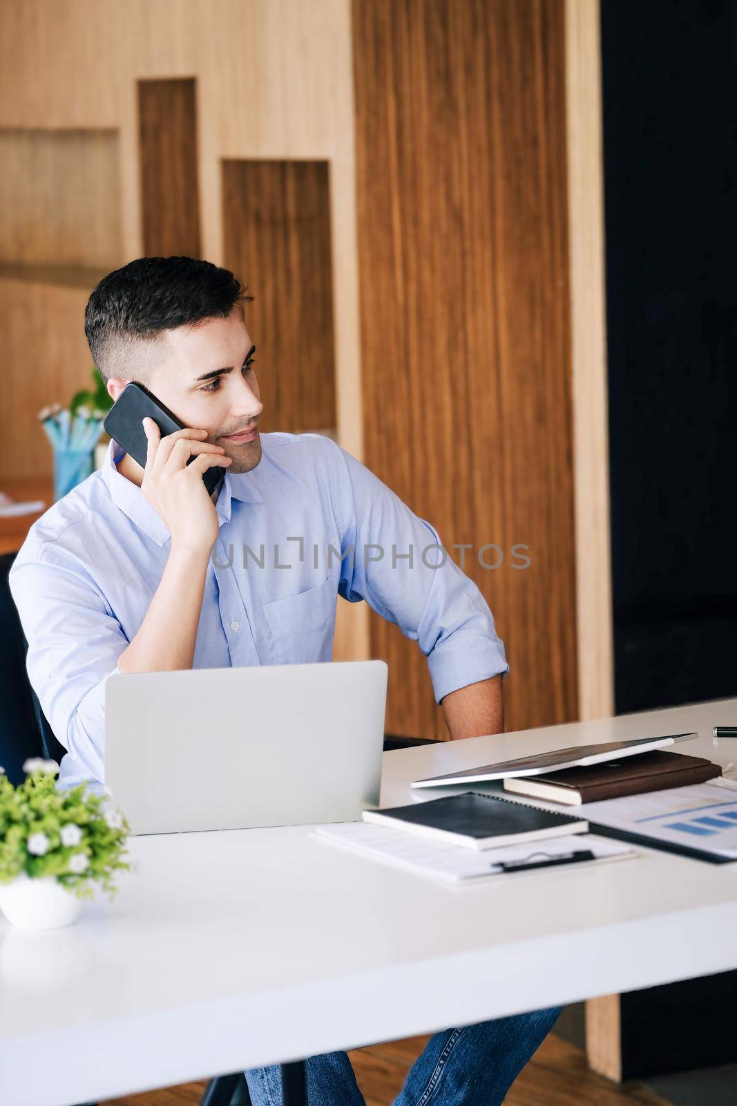 Male marketing manager using phone to talk to venture capital firm to increase profit potential. by Manastrong