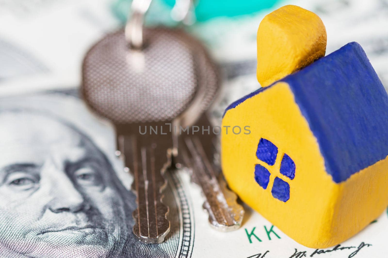 Miniature yellow toy house with keys on 100 (one hundred) euros bill. Selective focus. by marketlan