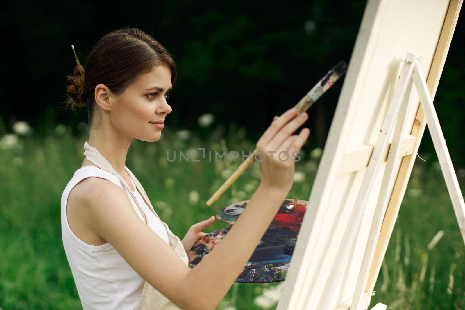 cheerful woman artist painting a picture outdoors creative art by Vichizh