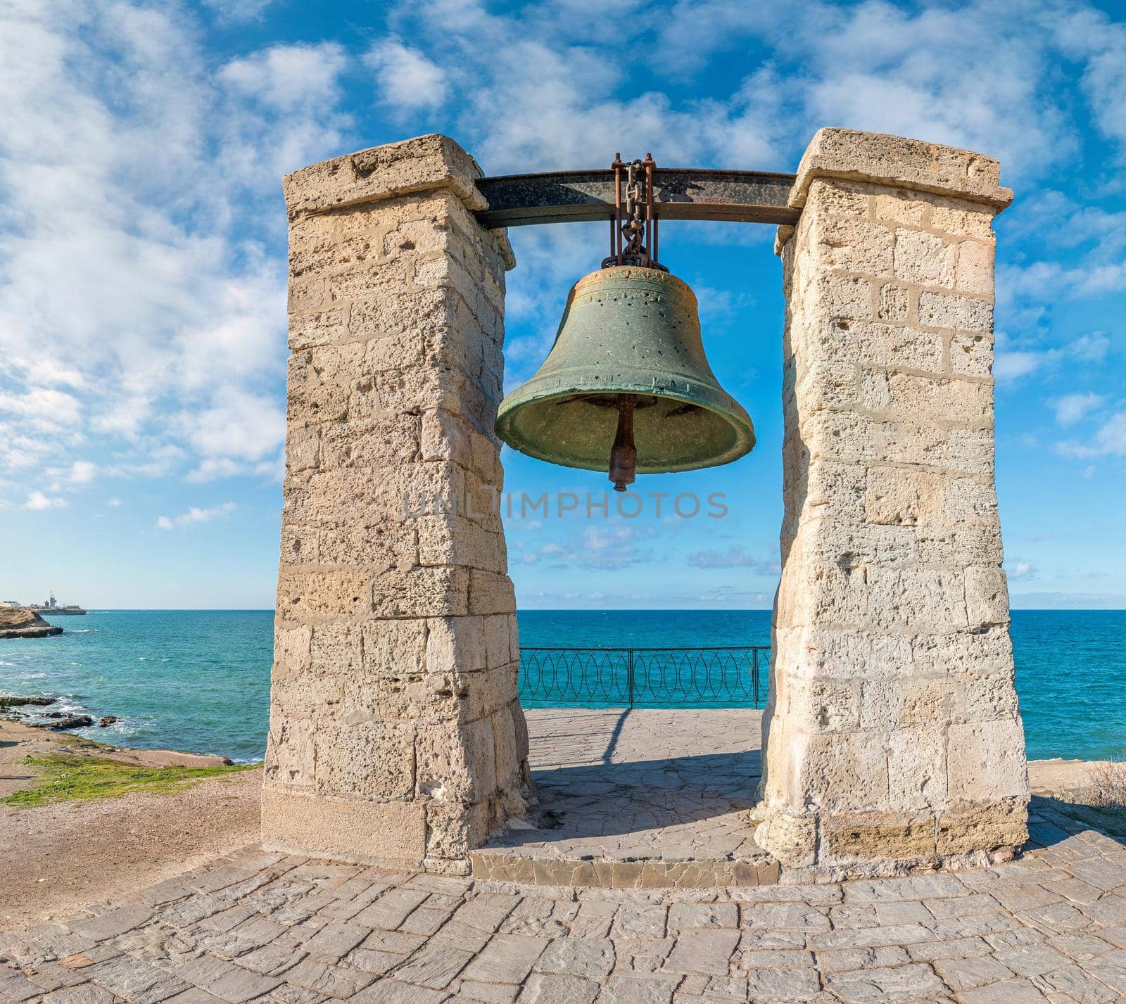 Big bronze bell on the sea shore in the ancient Greek city Chersonesus, Hersones in Sevastopol, Crimea. Copy space. Travel and relax concept. by panophotograph