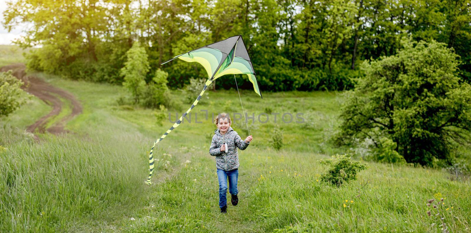 Happy little girl flying bright kite by tan4ikk1