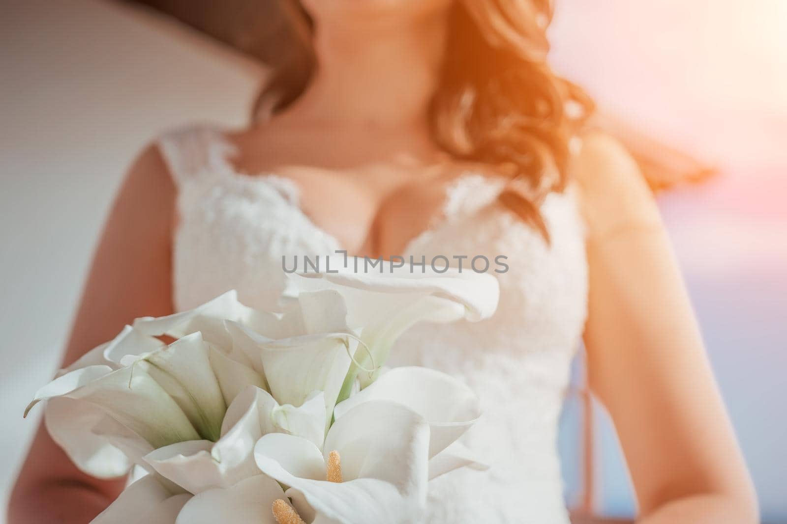 Beautiful young brunette girl of European appearance. Large single portrait with a bouquet of flowers. Wedding makeup and hairstyle. Model. Morning of the bride or fees. Puffy lips and expressive eyes