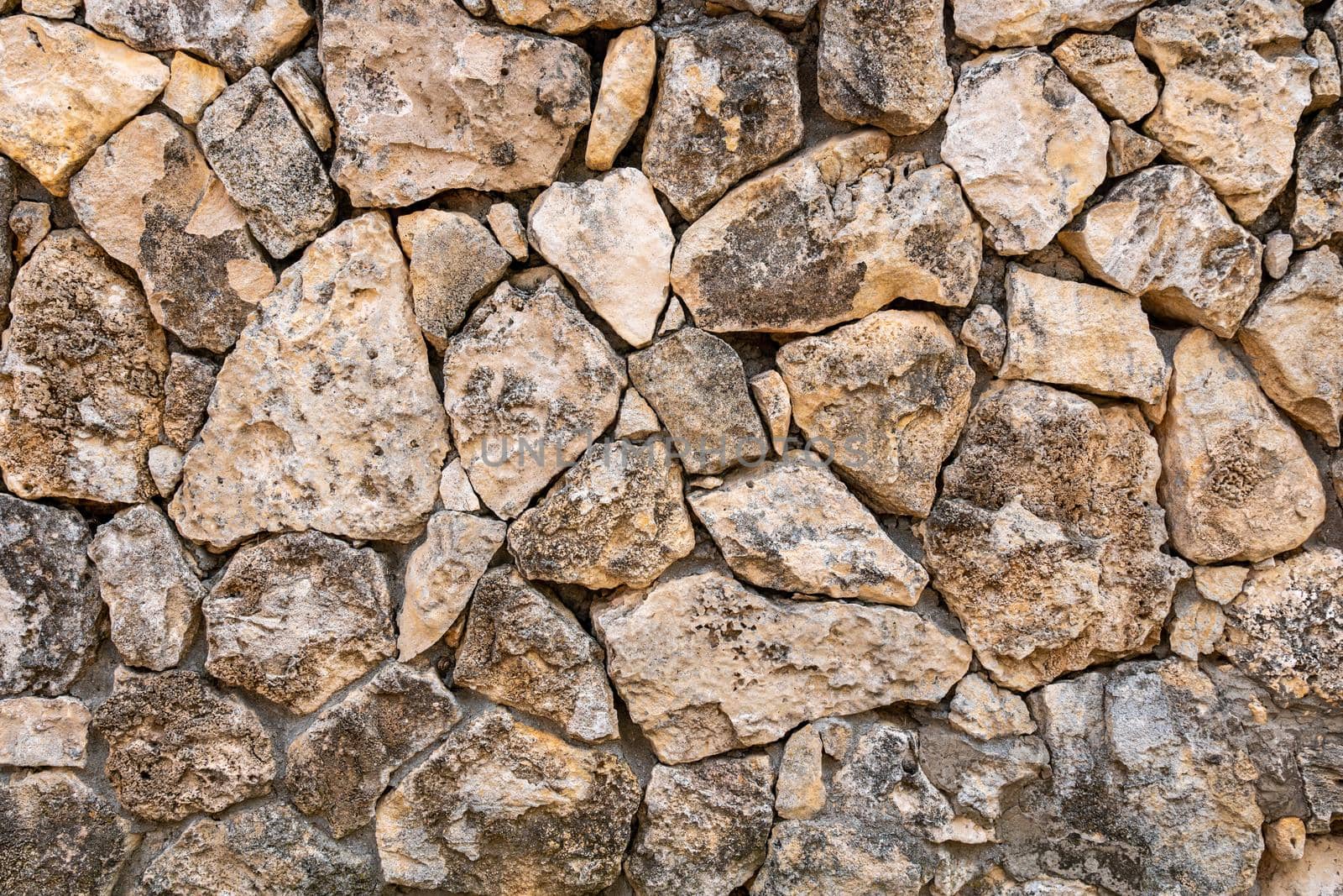 Background of limestone masonry. The surface is decorated with natural material. The wall is made of wild stone by panophotograph