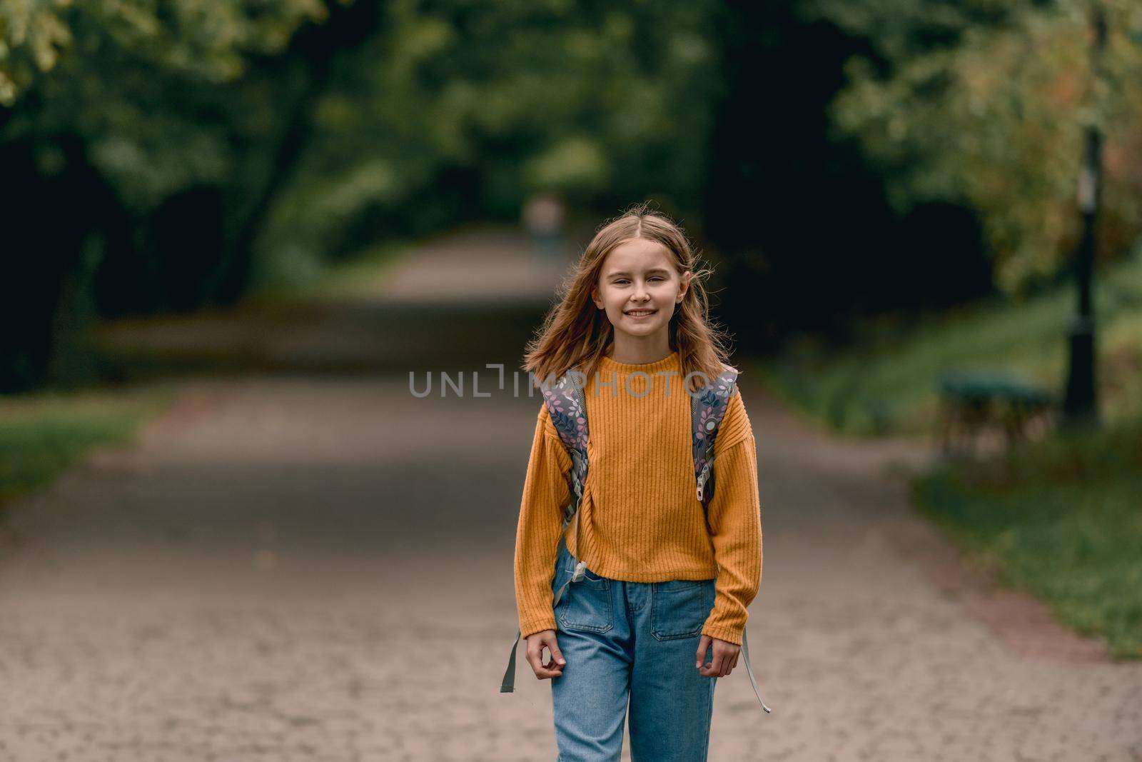 Happy school girl with backpack portrait outdoors. Portrait of schoolchild at autumn at the street