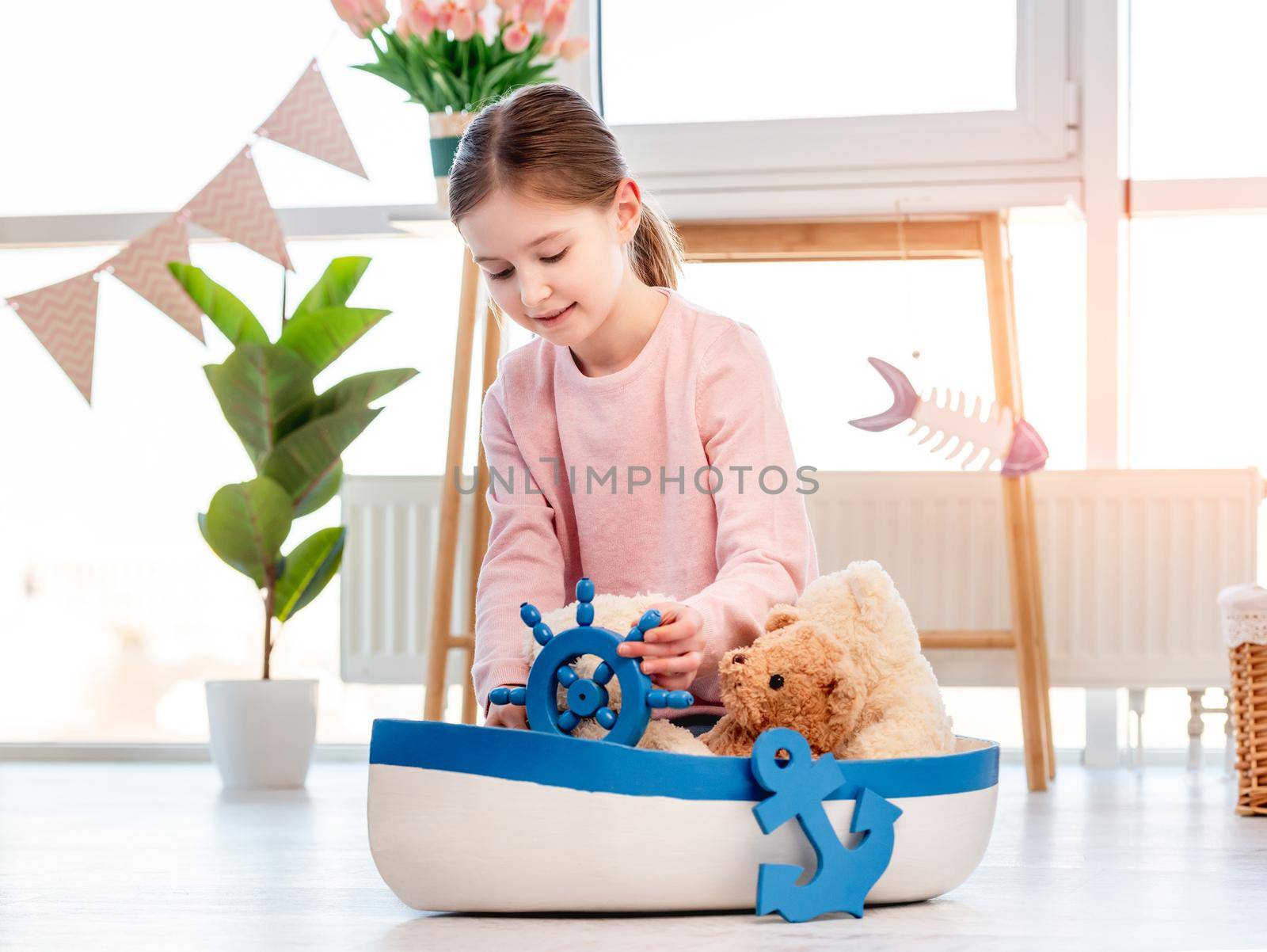 Little girl playing with toys and ship. Concept of creativity and child imagination