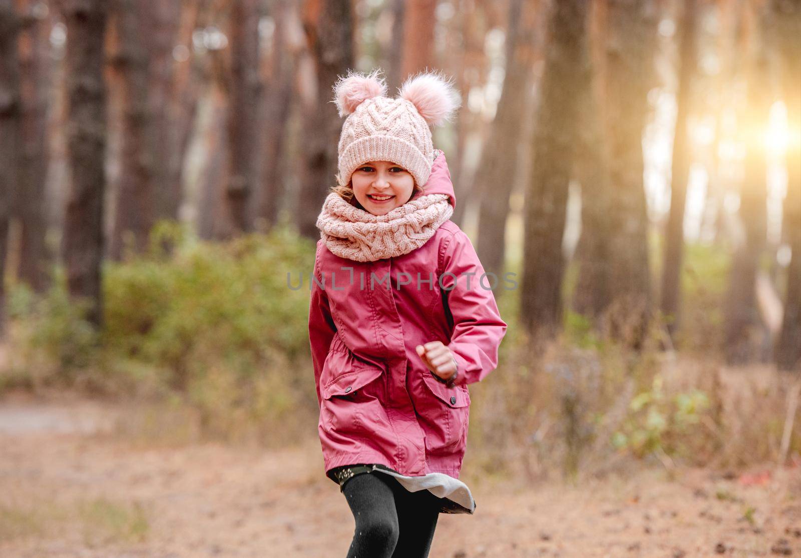 Smiling little girl running in pine forest by tan4ikk1