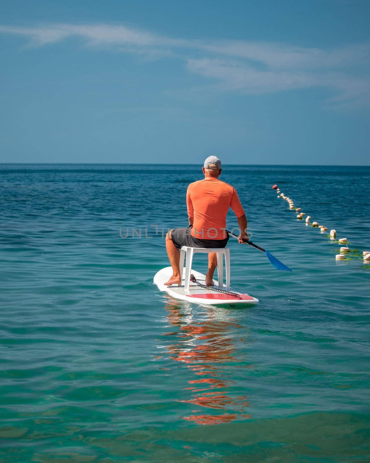 Strong men floating on a SUP boards on a sunny day