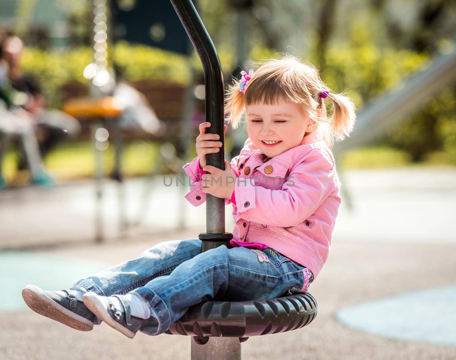 Cute little girl on outdoor playground equipment