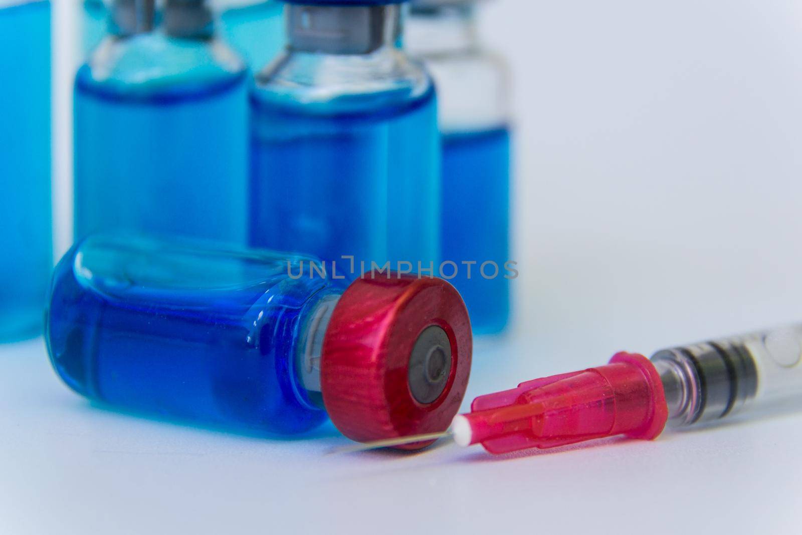 close up group of vaccine vials and syringe