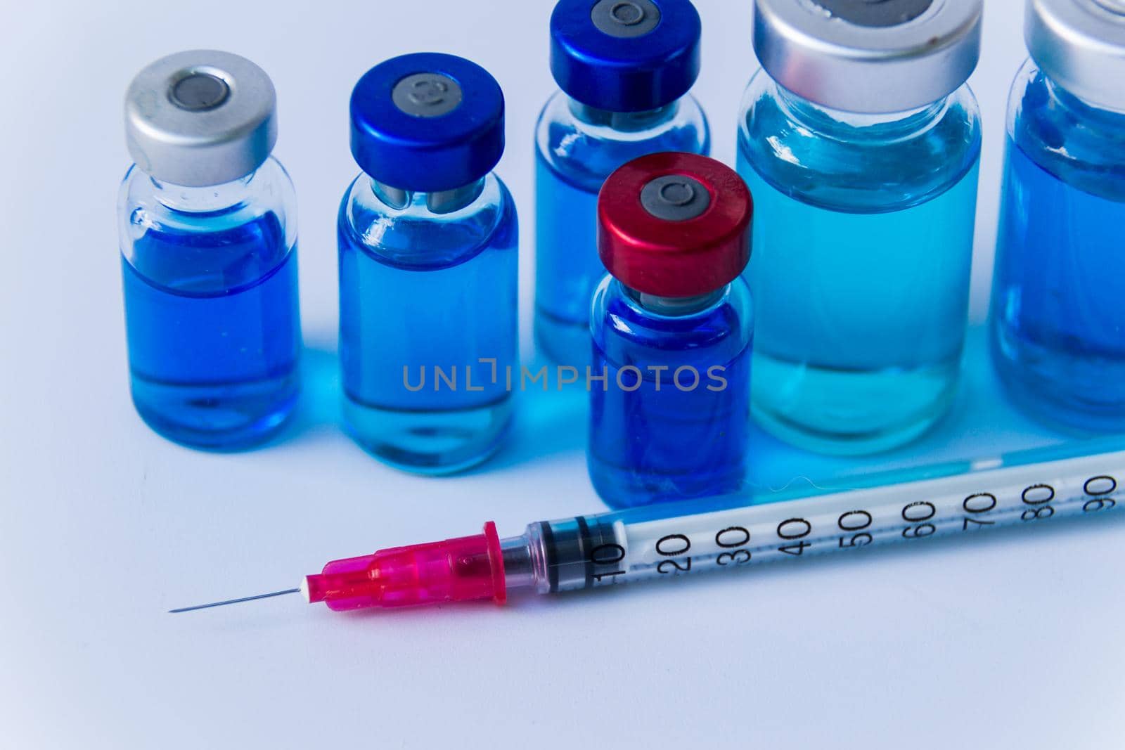 group of vaccine vials and syringe by GabrielaBertolini