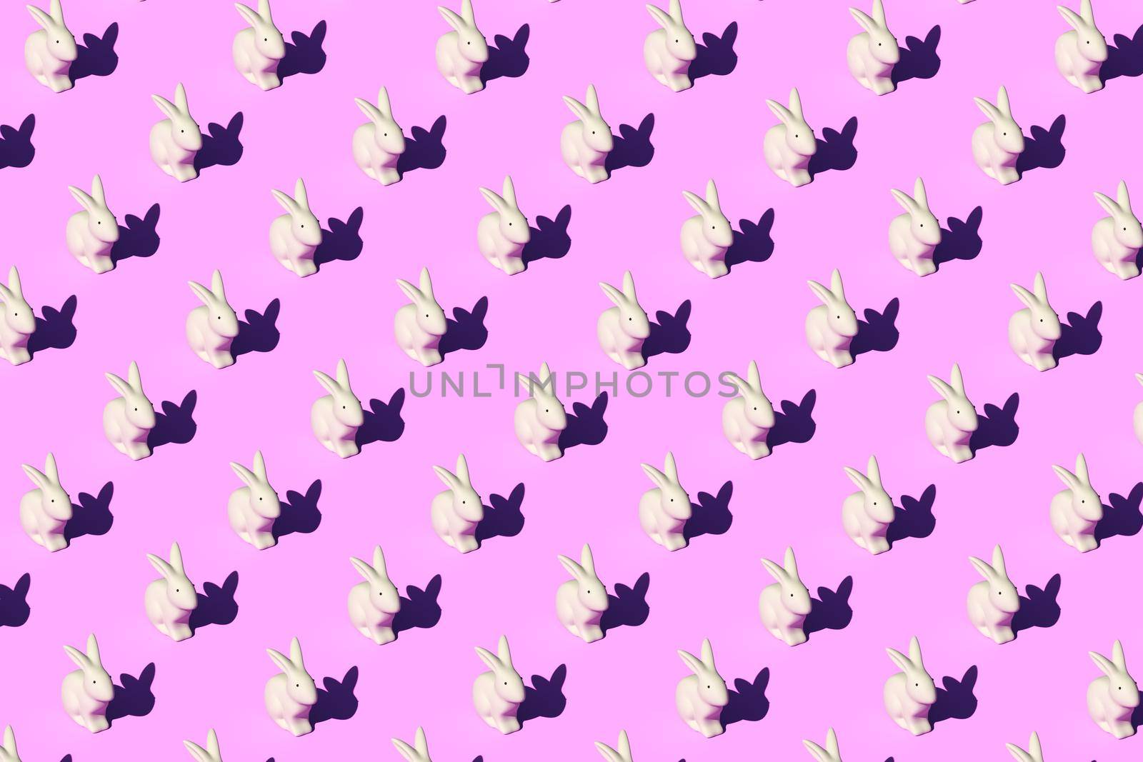 Pattern composition of Easter bunnies on pastel red background. Minimalist isometric concept.