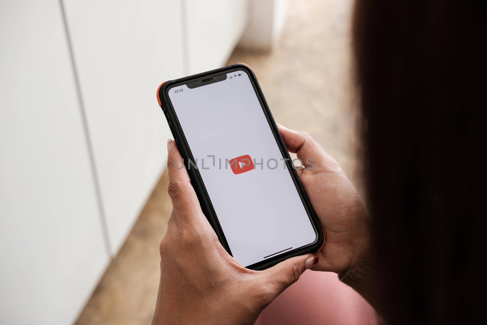 CHIANG MAI, THAILAND - NOV 7, 2021: woman holding iphone x with Youtube apps on screen. YouTube is the popular online video sharing website by nateemee