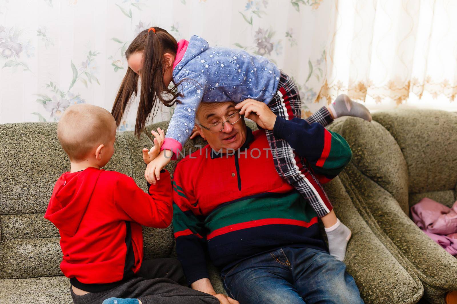 grandfather spends time with grandchildren in the living room