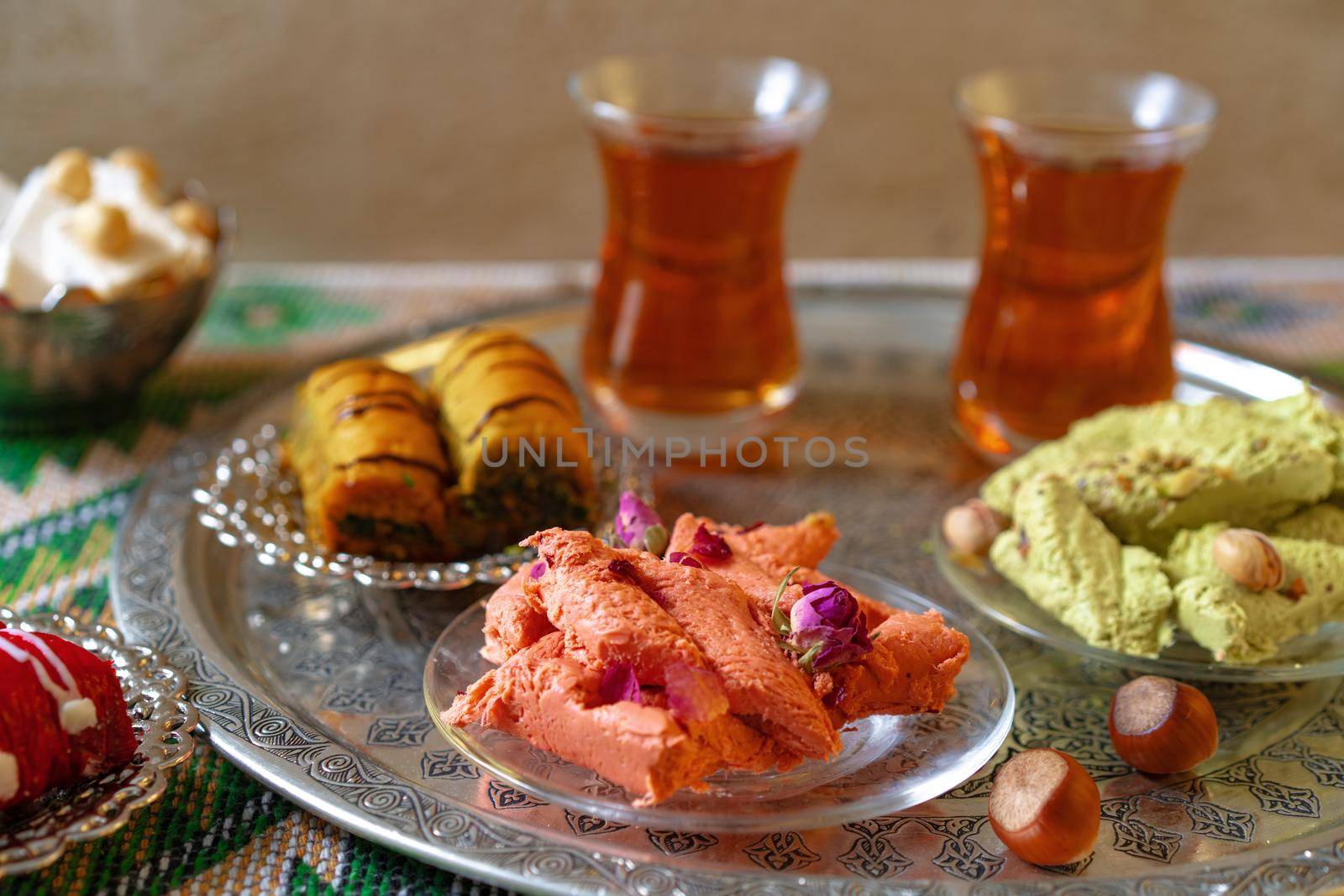 Turkish sweet baklava on metal tray with Turkish tea, close up