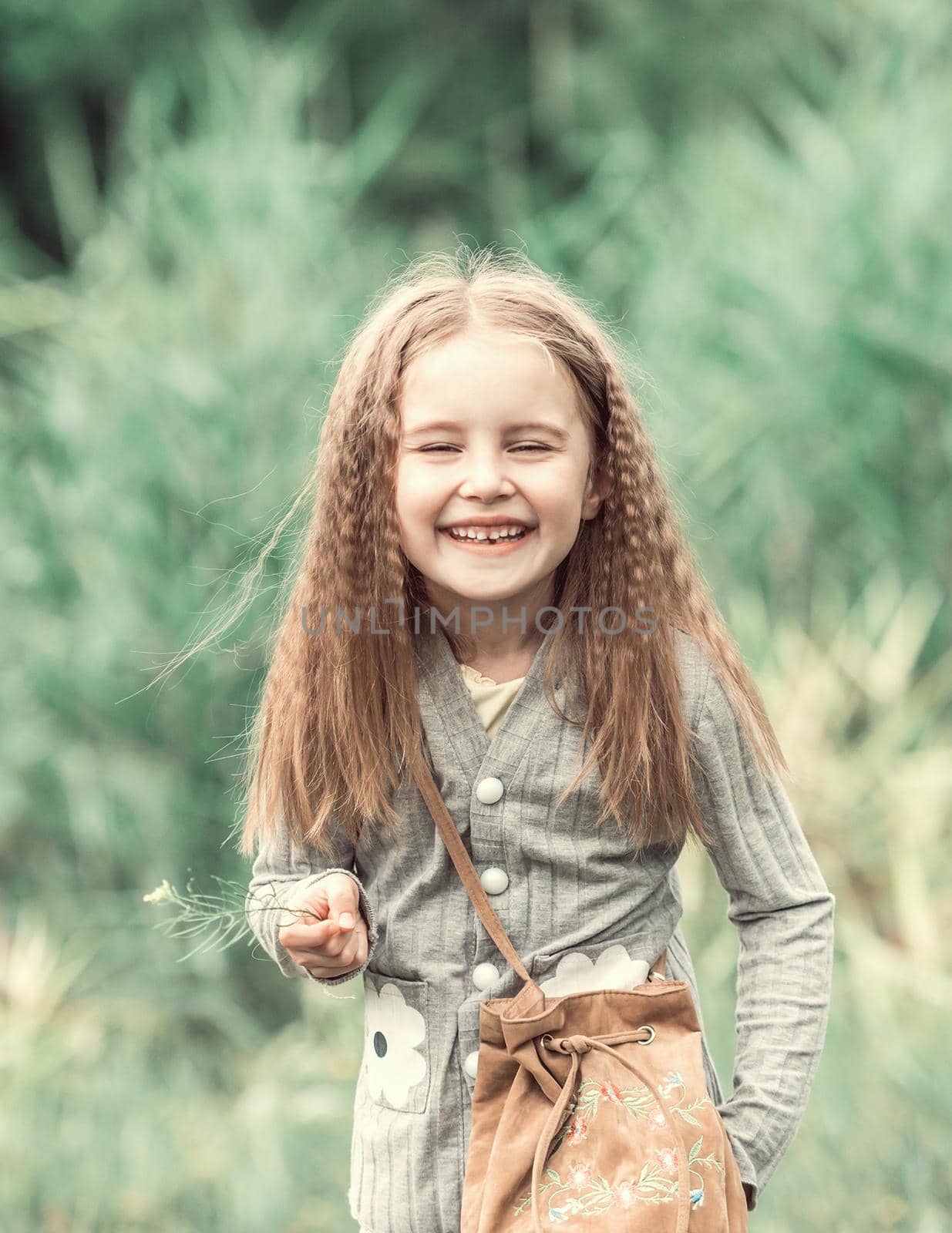 cute little girl is walking in the summer wood