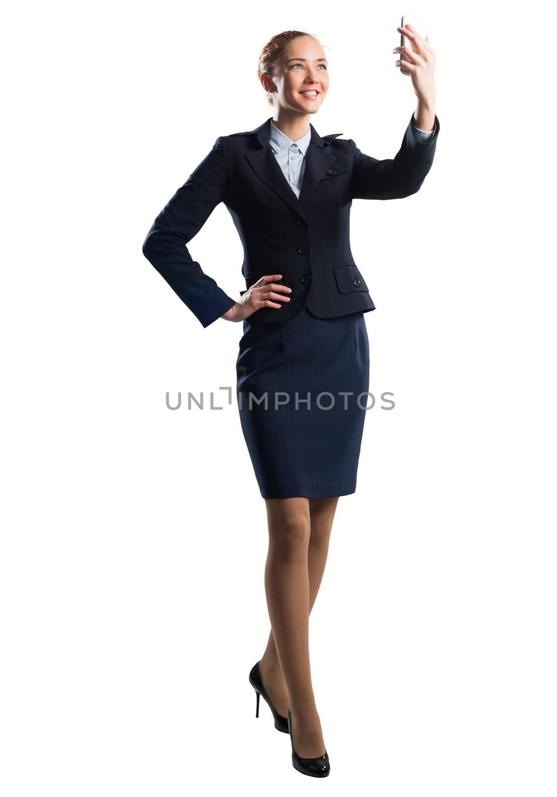 Young beautiful woman taking selfie photo with smartphone. Confident and stylish businesswoman in dark blue suit. Corporate businessperson isolated on white background. Mobile communication layout.