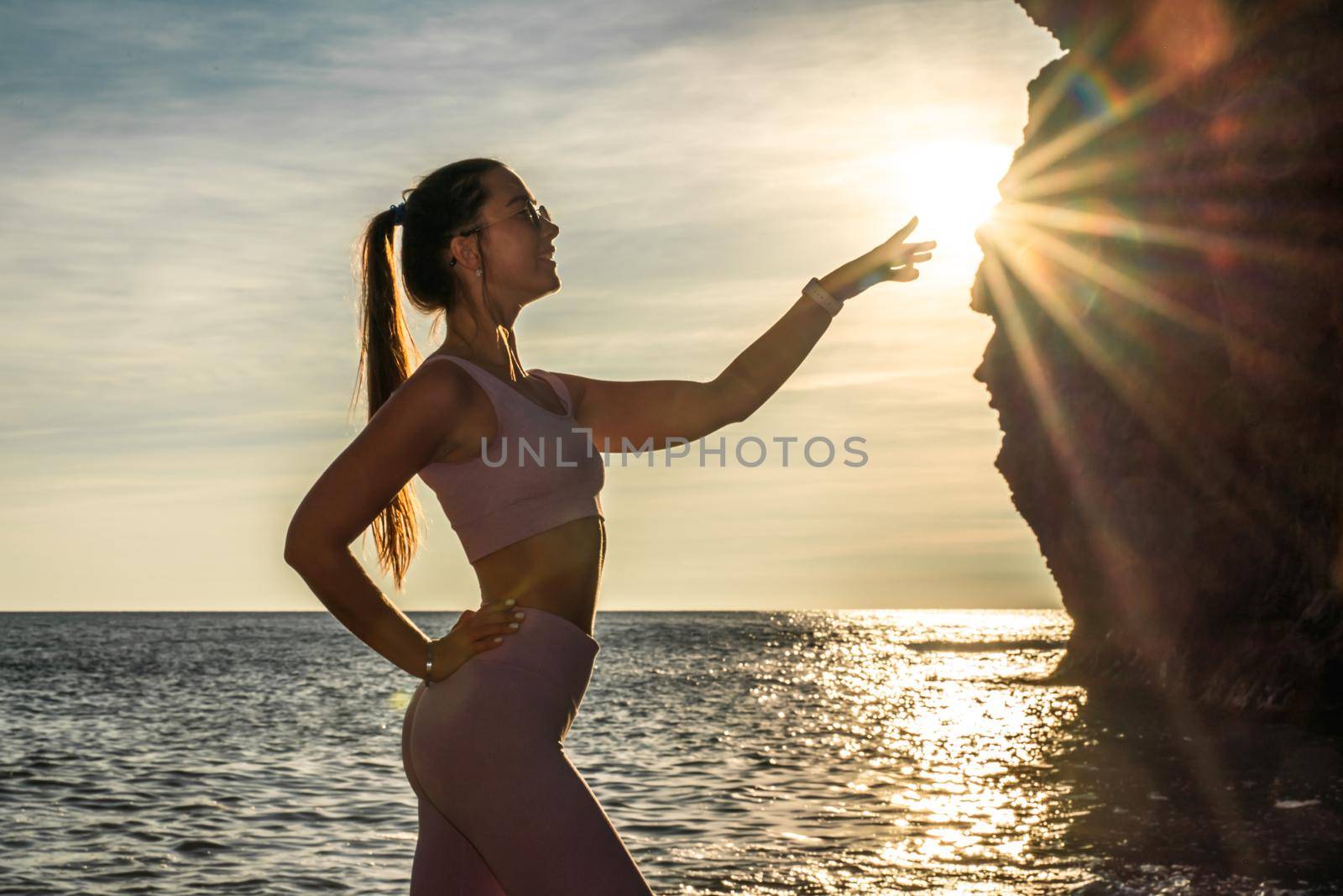 Girl gymnast is training on the beach by the sea sunset. Does twine. Photo series