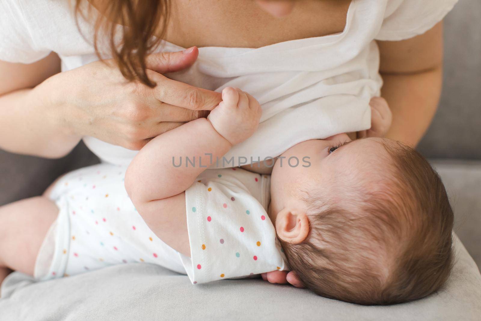 Crop close up view of young mother feeding little baby with breast