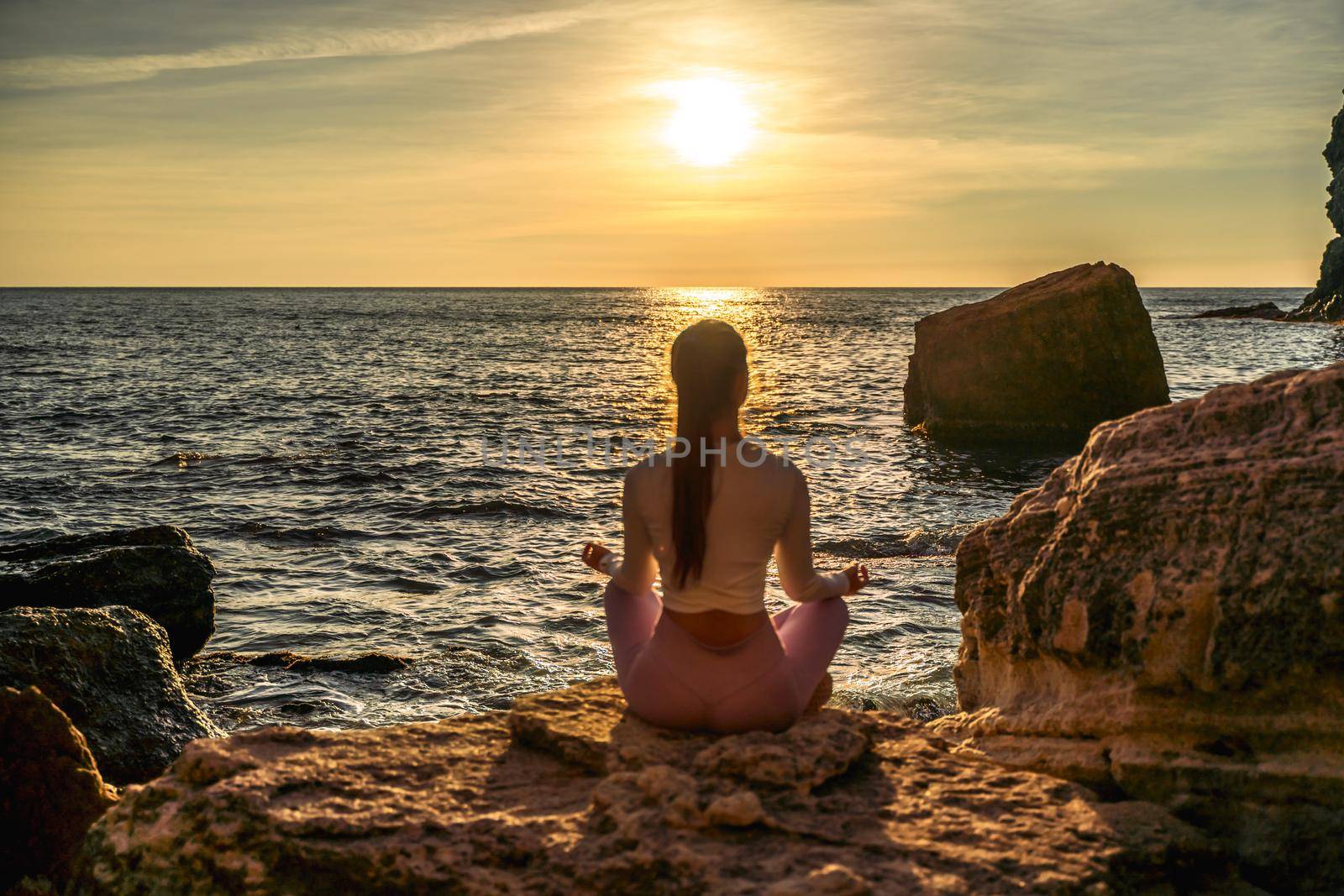 Young woman practicing yoga outdoors. Harmony and meditation concept. Healthy lifestyle by Matiunina